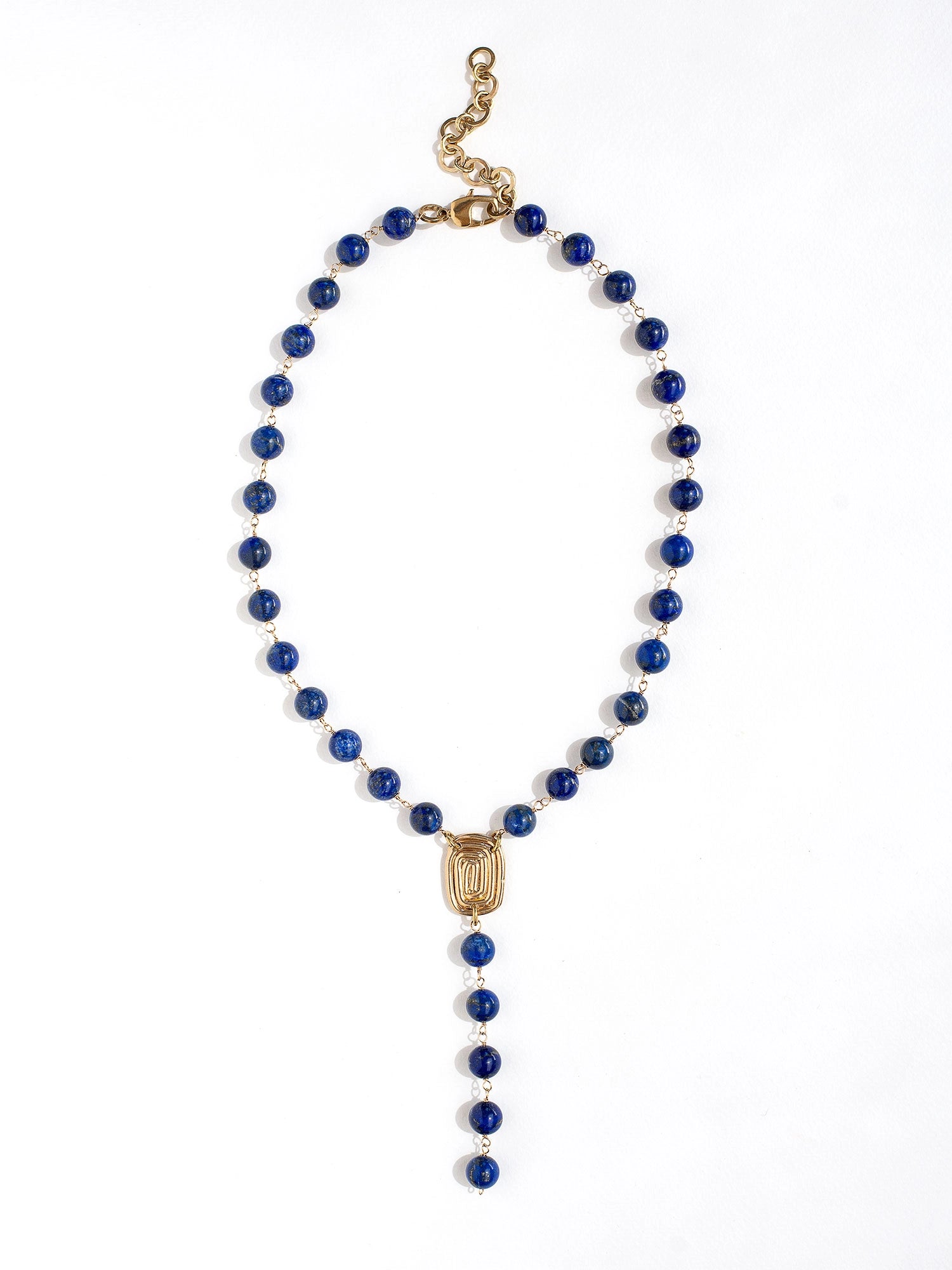A lapis lazuli beaded lariat necklace with brass scroll details by Canadian jewelry designer Michelle Ross