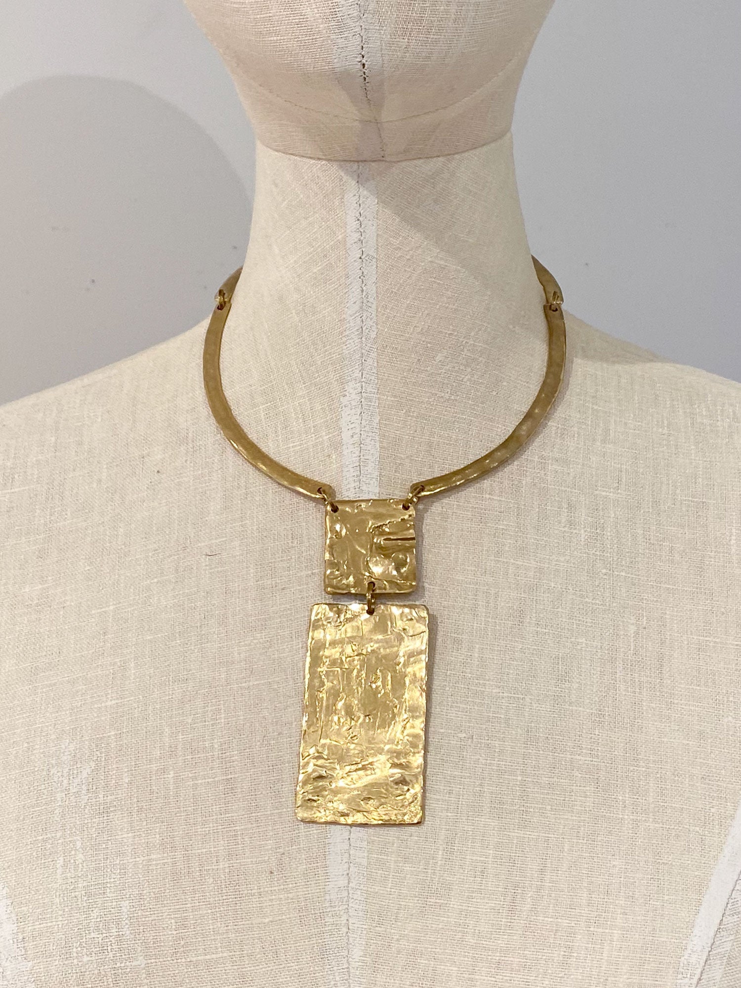 gold coloured brass collar necklace with rectangular pendant