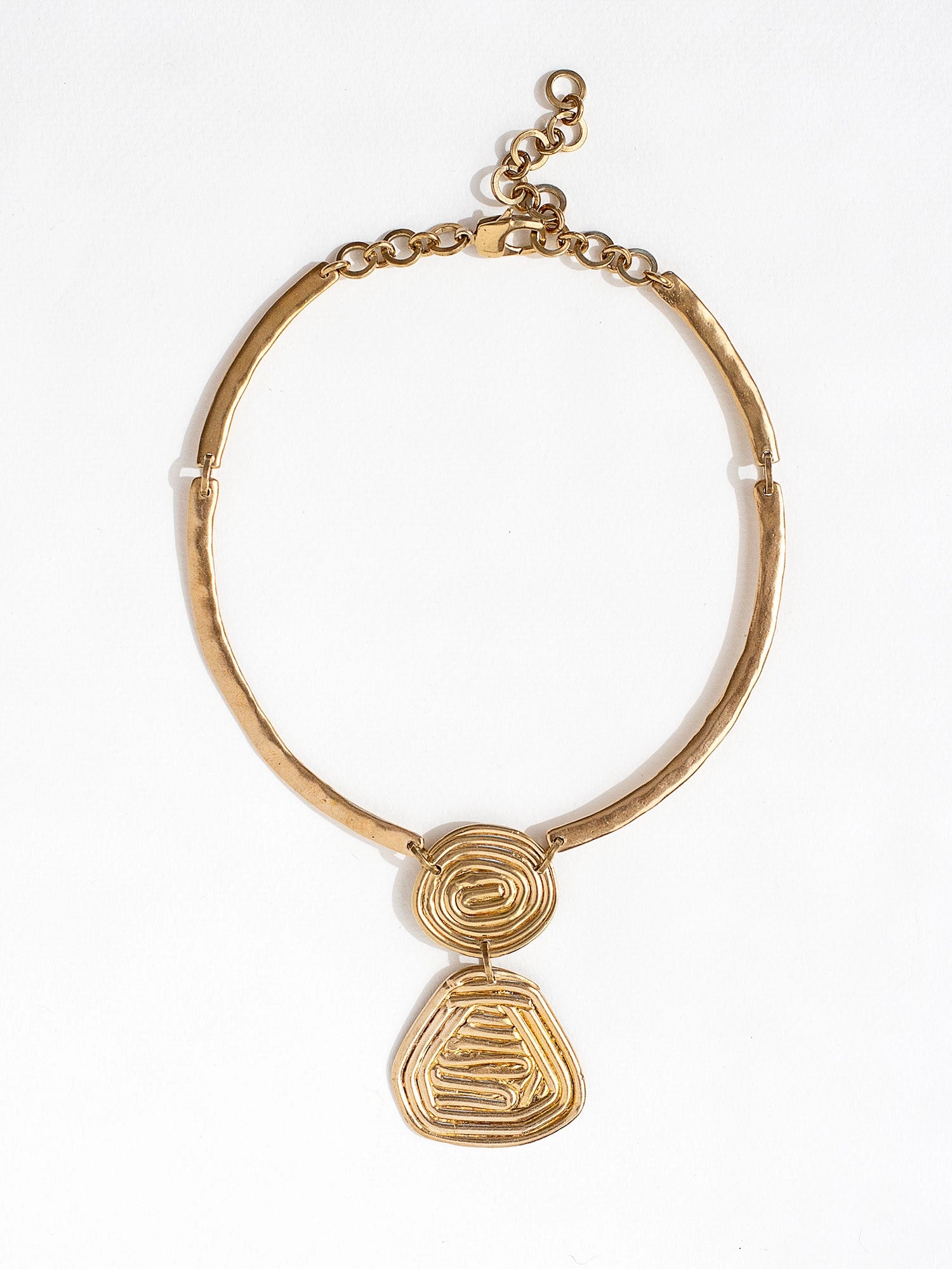A solid brass collar necklace with a layered circular spiral pendants by Canadian jewelry designer Michelle Ross