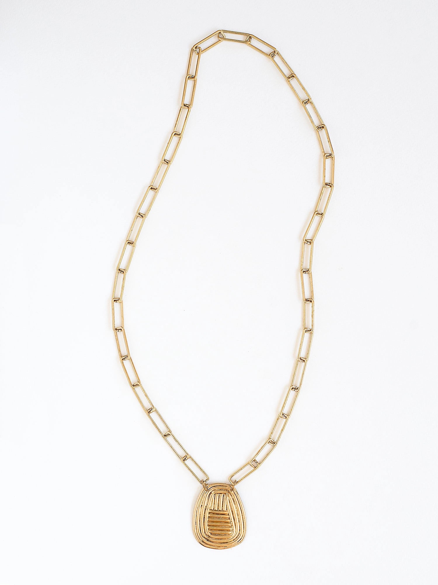 A brass chain link necklace with spiral circular pendant handcrafted by Canadian jewelry designer Michelle Ross