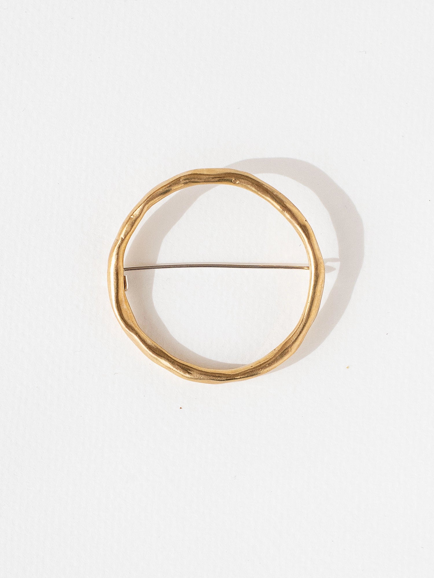 a circular handmade brass brooch by Toronto jewellery designer Michelle Ross