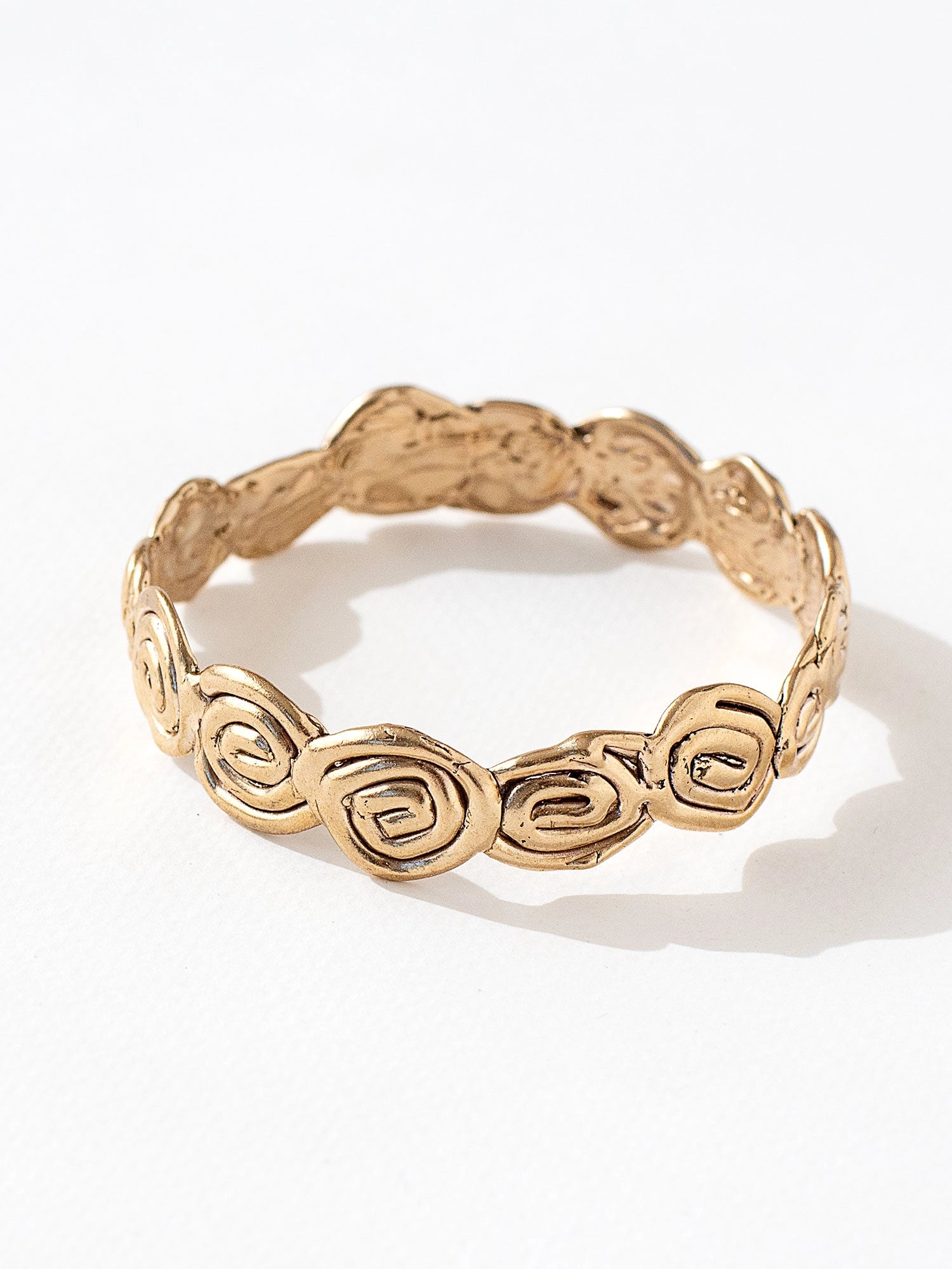 A solid brass bangle bracelet with swirl hand-formed details by Canadian jewelry designer Michelle Ross