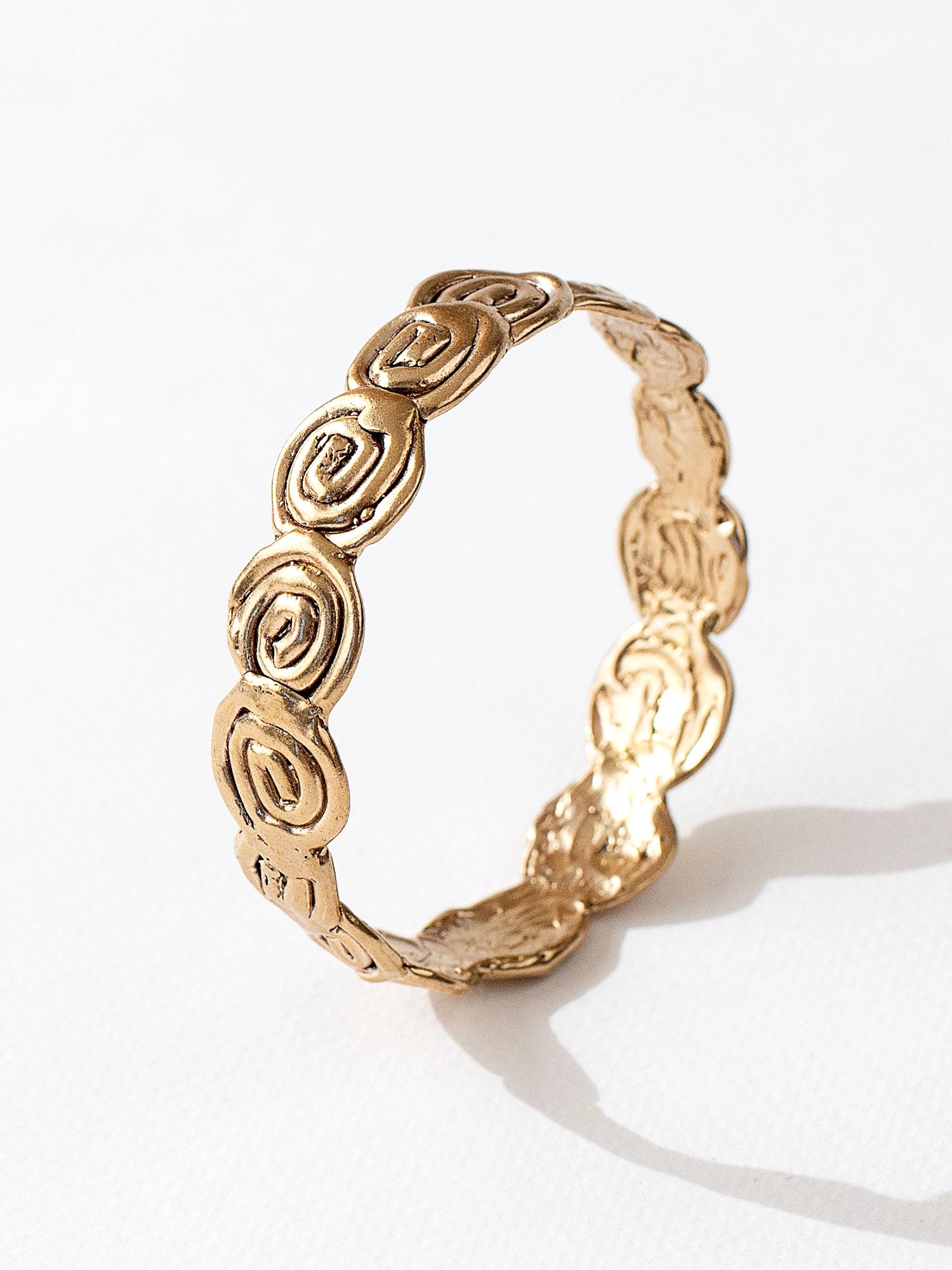 A solid brass bangle bracelet with swirl hand-formed details by Canadian jewelry designer Michelle Ross