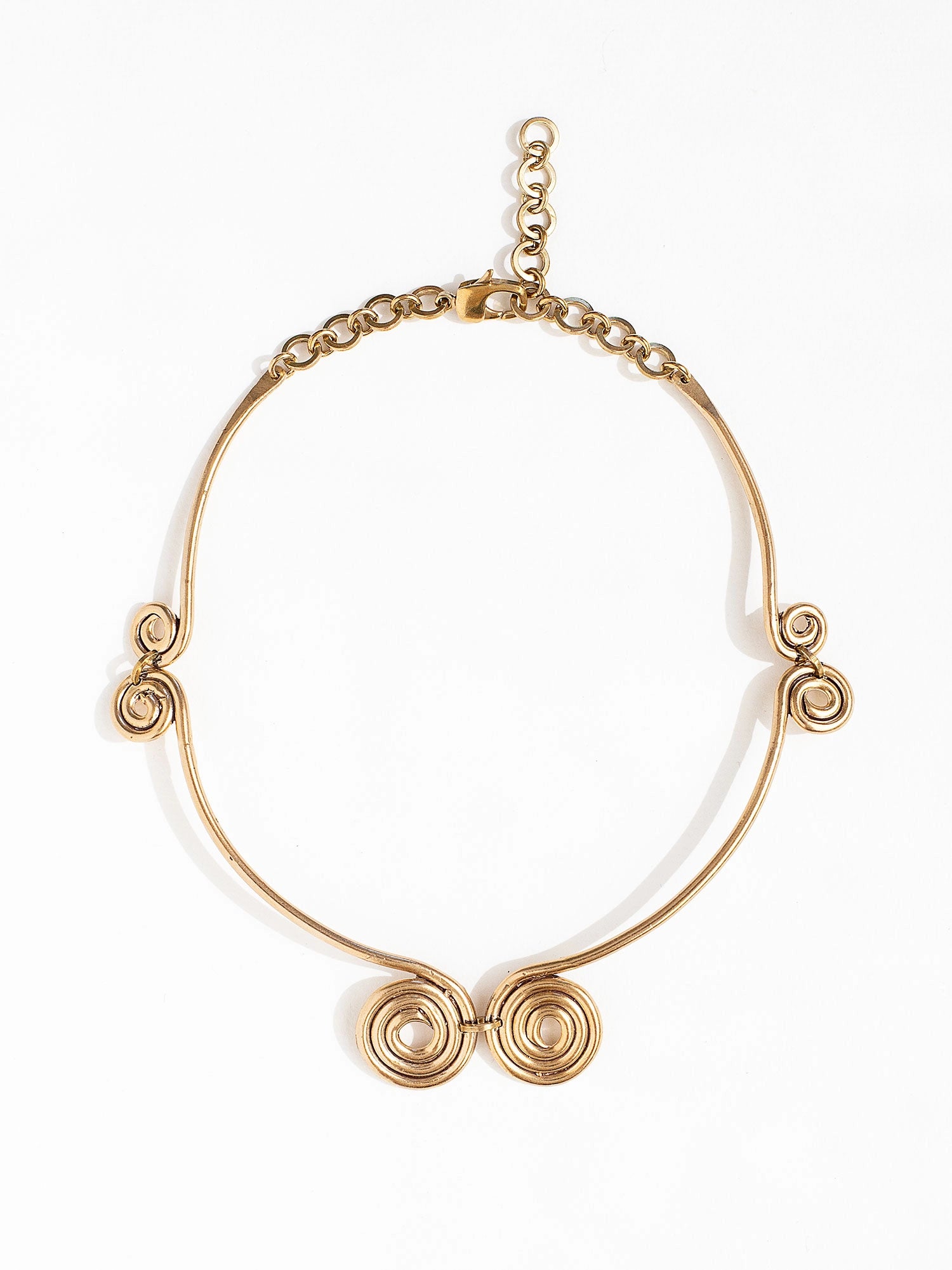 A solid brass collar necklace with several circular spiral details by Canadian jewelry designer Michelle Ross