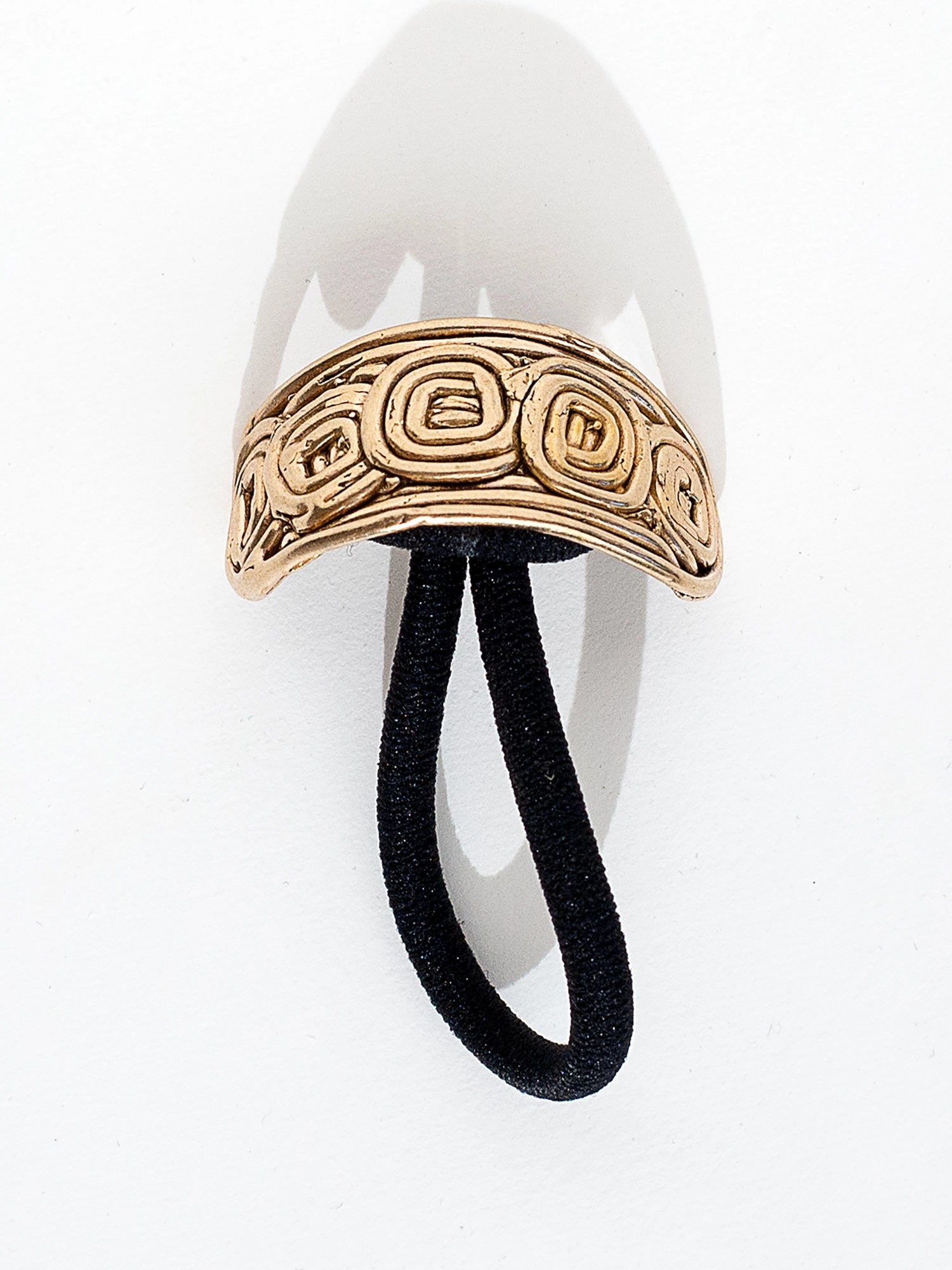 A brass solid hair tie with spiral scroll detail by Canadian jewelry designer Michelle Ross