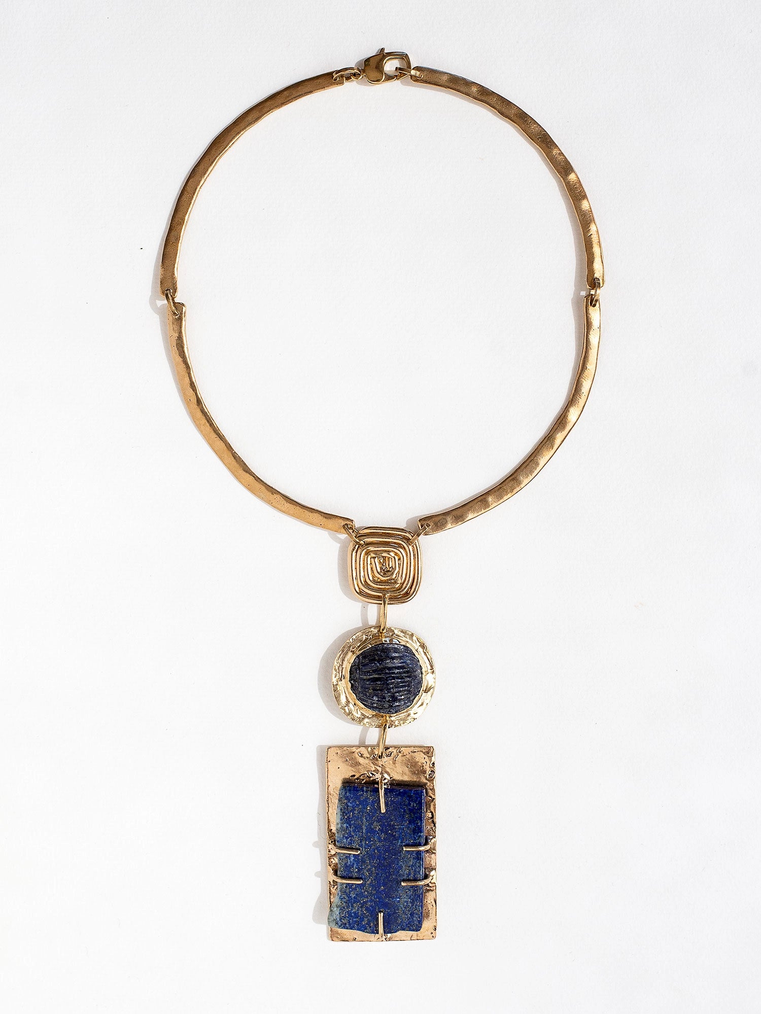 A solid brass collar necklace with a large statement lapis lazuli pendant by Canadian jewelry designer Michelle Ross