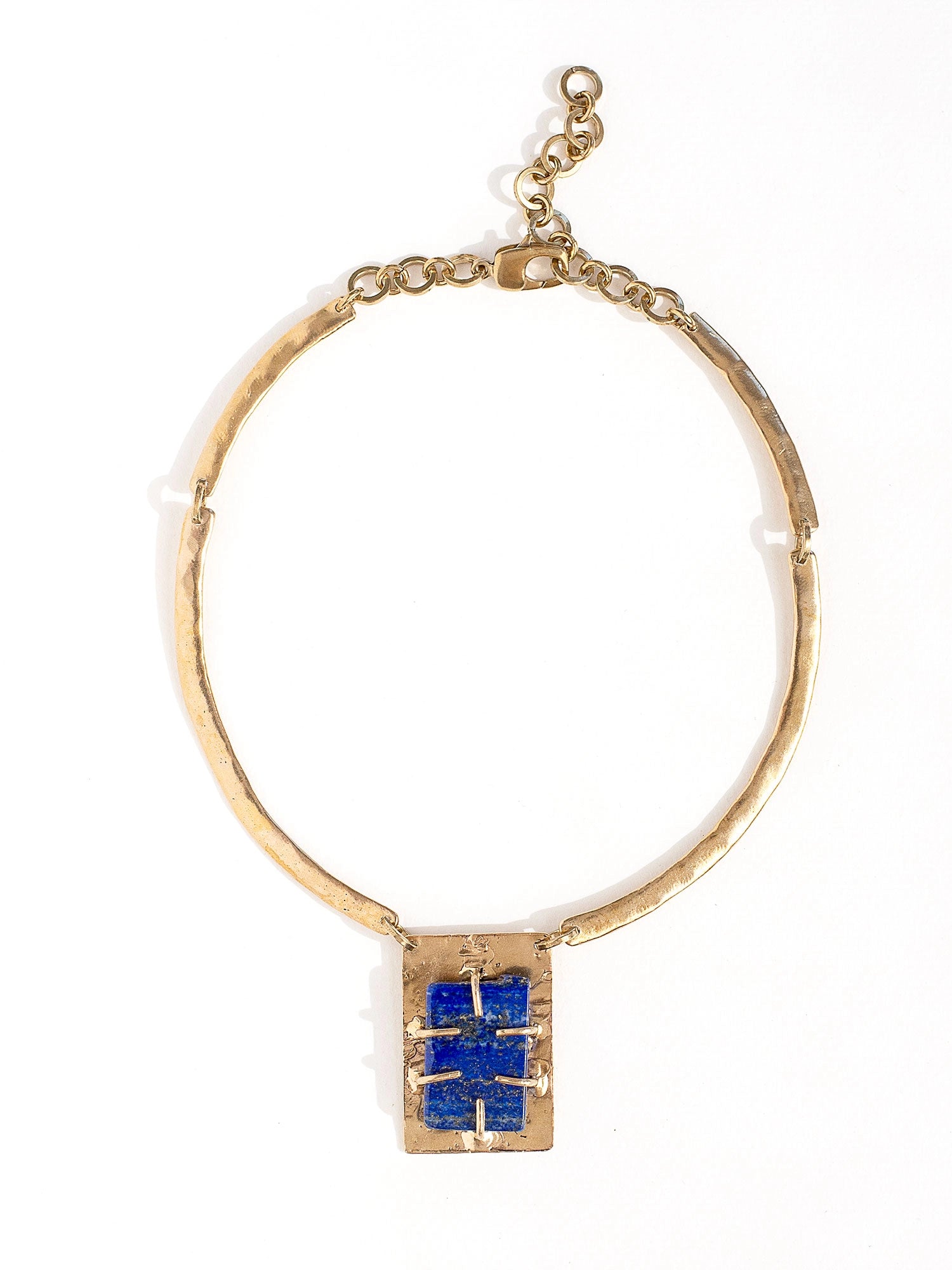 A solid brass collar necklace with a statement rectangular lapis lazuli pendant by Canadian jewelry designer Michelle Ross