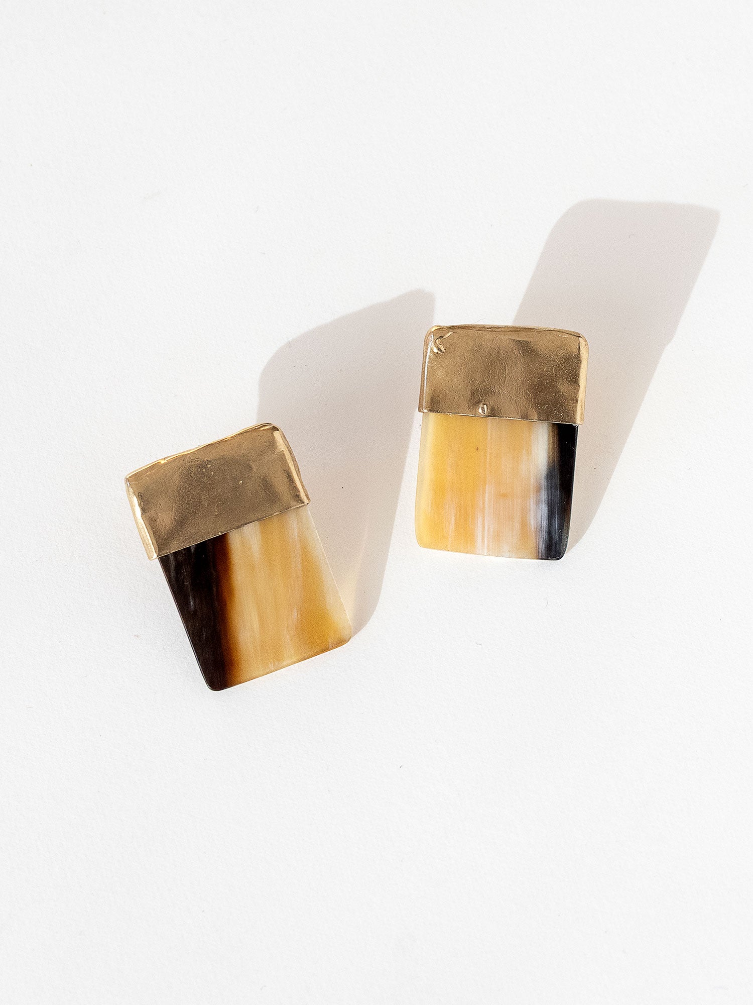 Pair of statement stud earrings with brass tops and brown horn bases in a square shape by Michelle Ross
