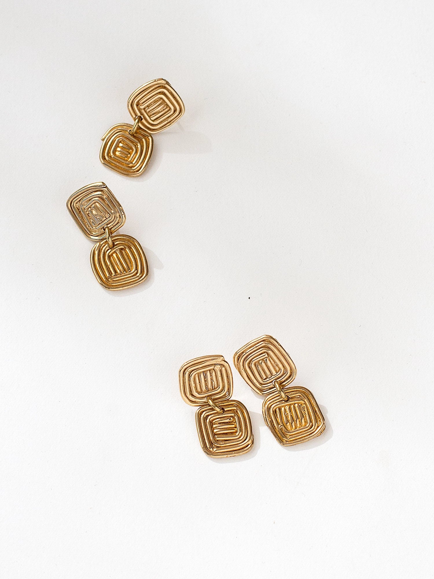 Two pairs of brass spiral drop earrings by contemporary designer Michelle Ross