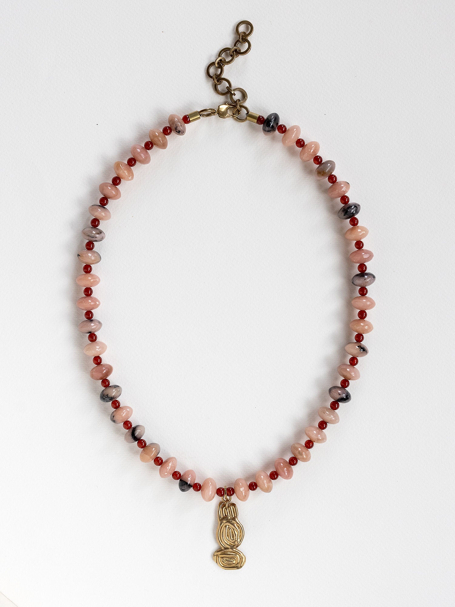 A beaded necklace featuring light pink stone with grey marbled beads, dark red beads, accented with a brass metal clasp by Canadian jewelry designer Michelle Ross