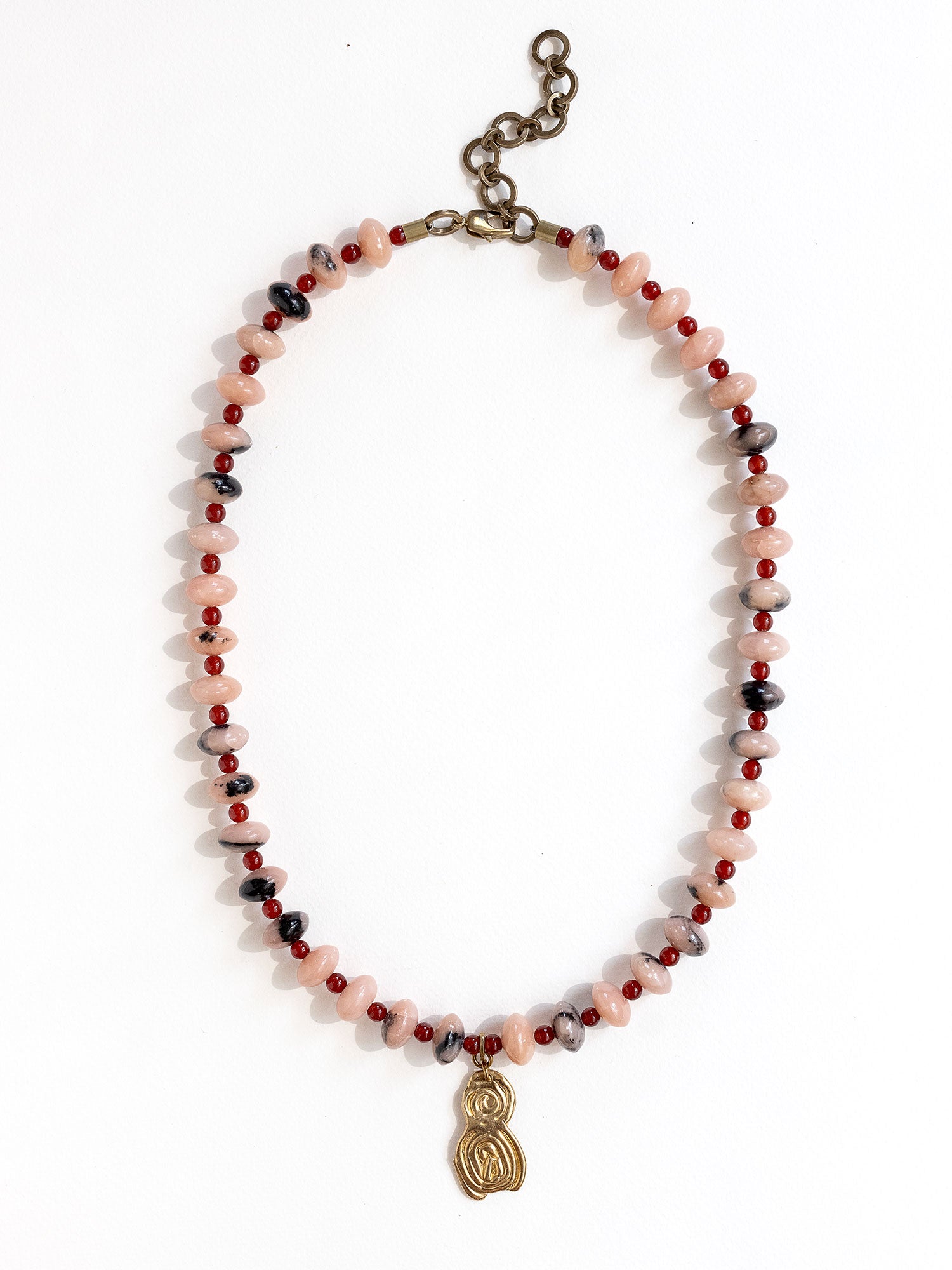 A beaded necklace featuring light pink stone with grey marbled beads, dark red beads, accented with a brass metal clasp by Canadian jewelry designer Michelle Ross