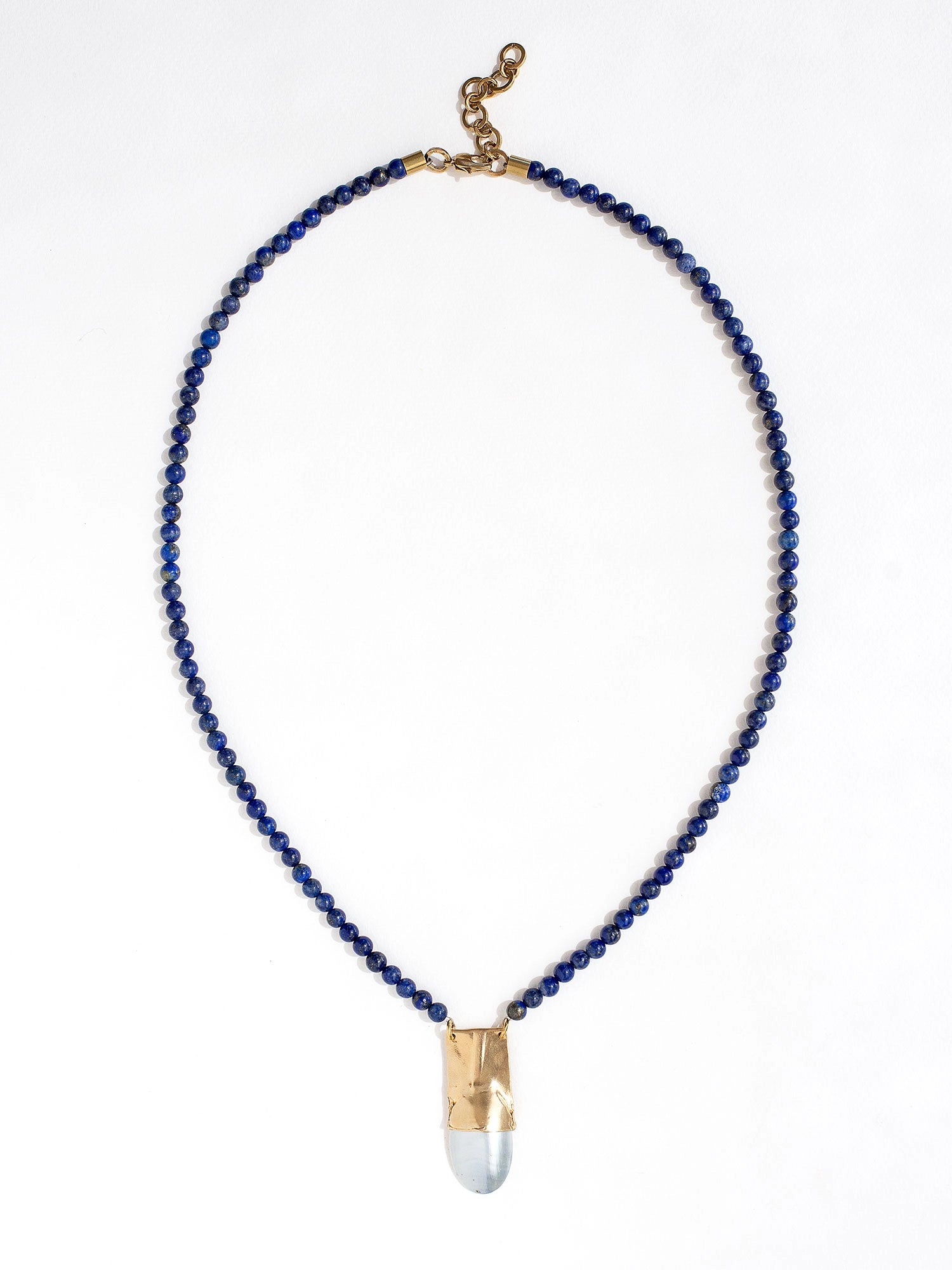 A lapis lazuli beaded necklace with a large statement mother of pearl and brass pendant by Canadian jewellery designer Michelle Ross