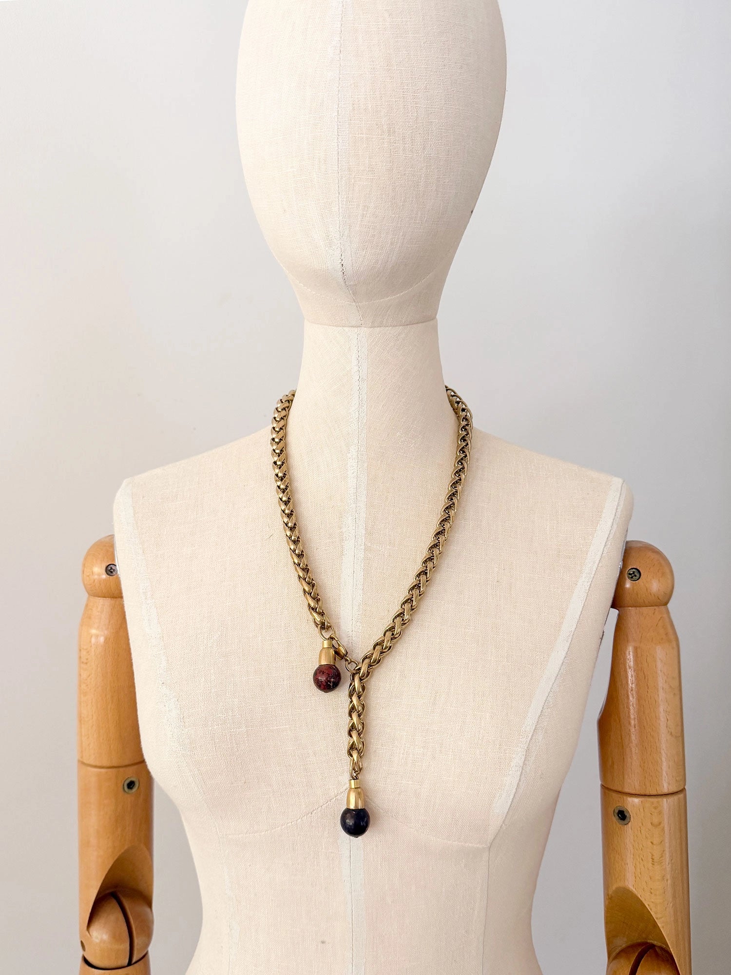 A brass chain lariat necklace with two red jasper bead tassels by Canadian jewelry designer Michelle Ross