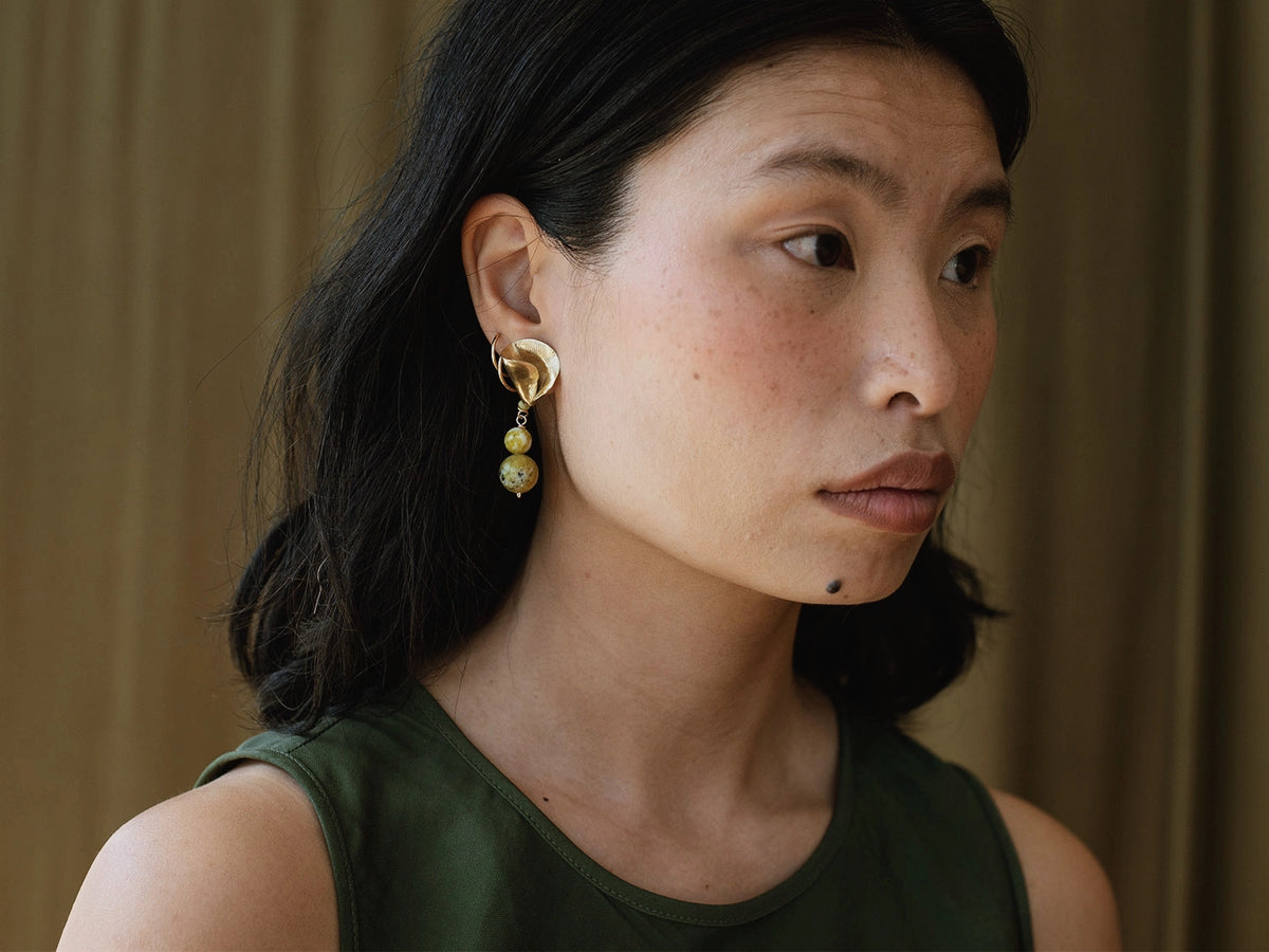 a woman wears brass and green serpentine quartz drop earrings by Canadian Jewelry designer Michelle Ross