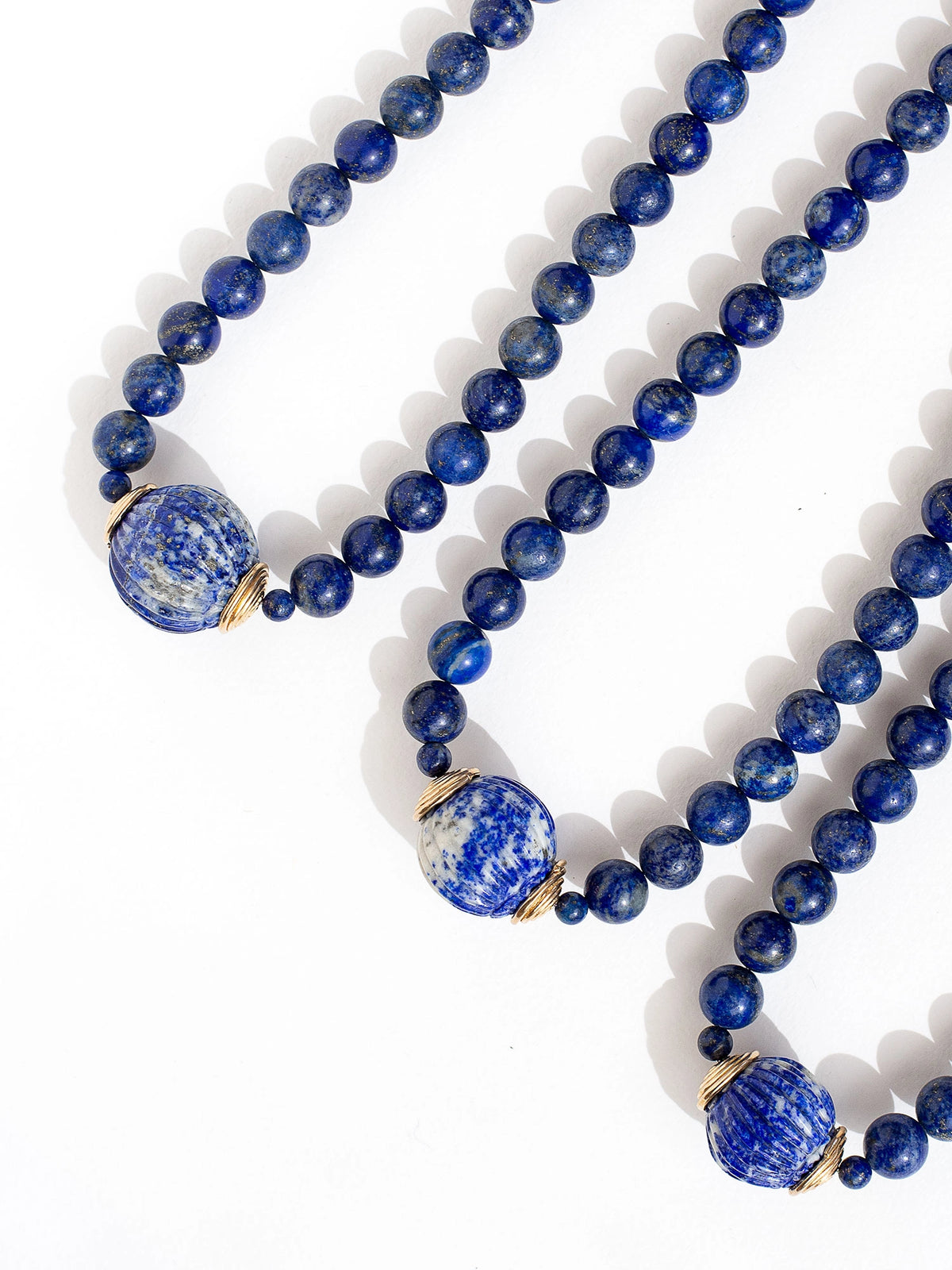 A beaded lapis lazuli strand necklace with large lapis lazuli and brass circular pendant by Canadian jewelry designer Michelle Ross