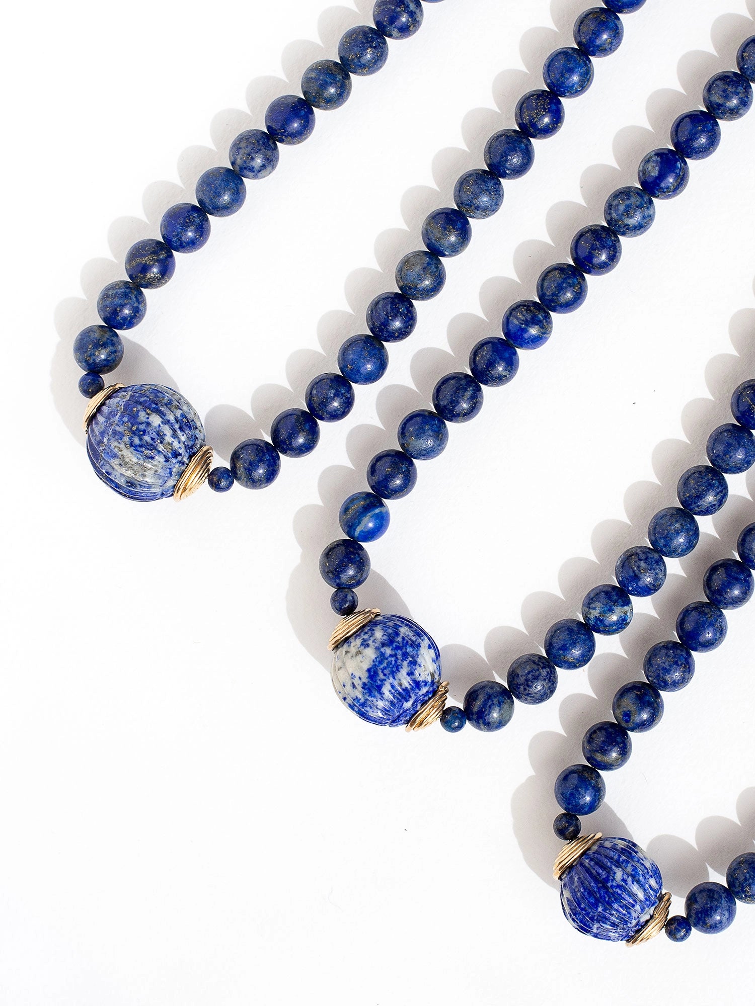 A beaded lapis lazuli strand necklace with large lapis lazuli and brass circular pendant by Canadian jewelry designer Michelle Ross