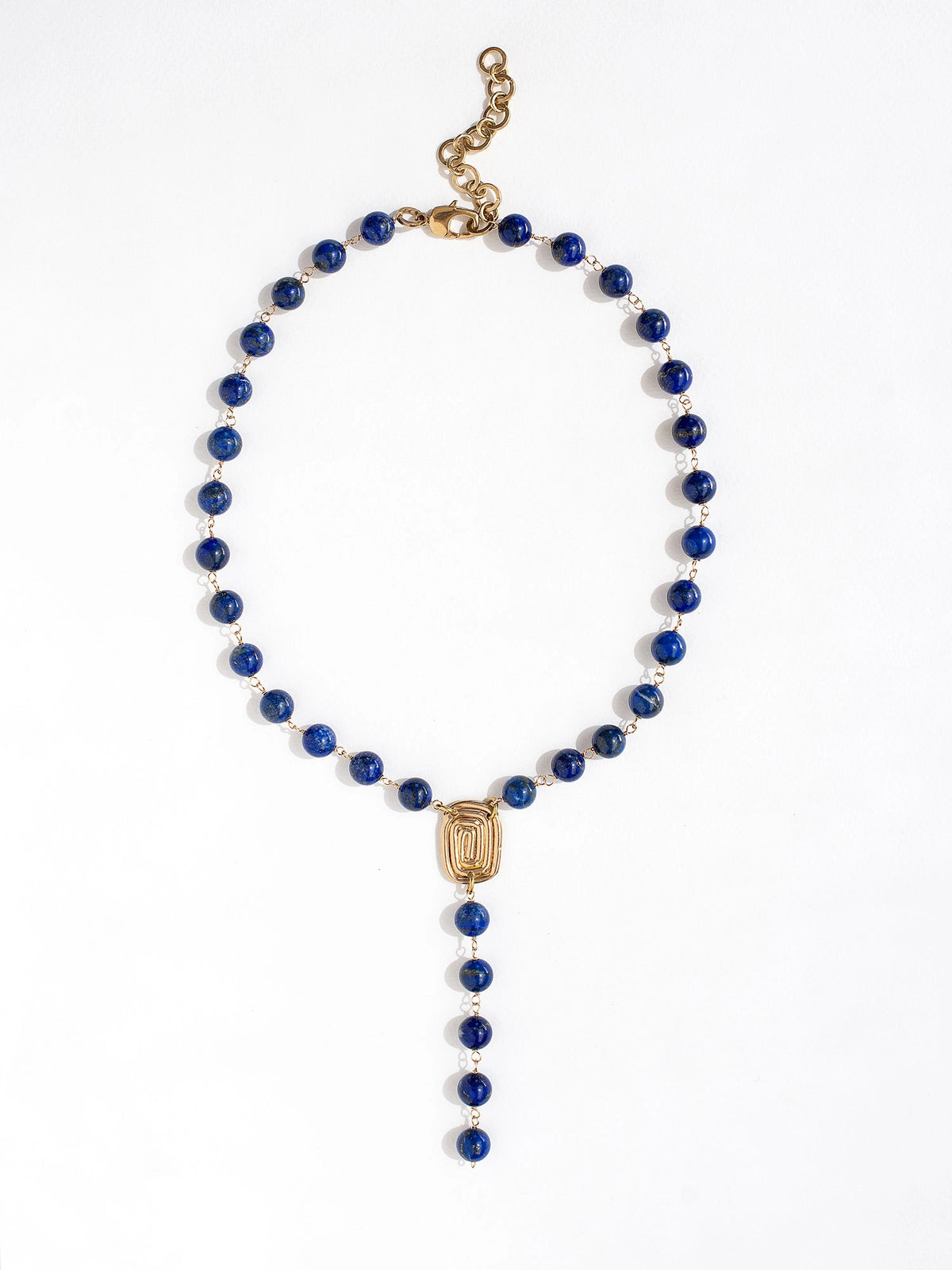 A lapis lazuli beaded lariat necklace with brass scroll details by Canadian jewelry designer Michelle Ross