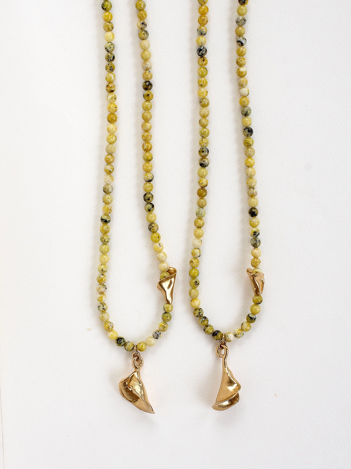 two serpentine quartz beaded necklaces with an abstract floral brass pendant by Canadian designer Michelle Ross