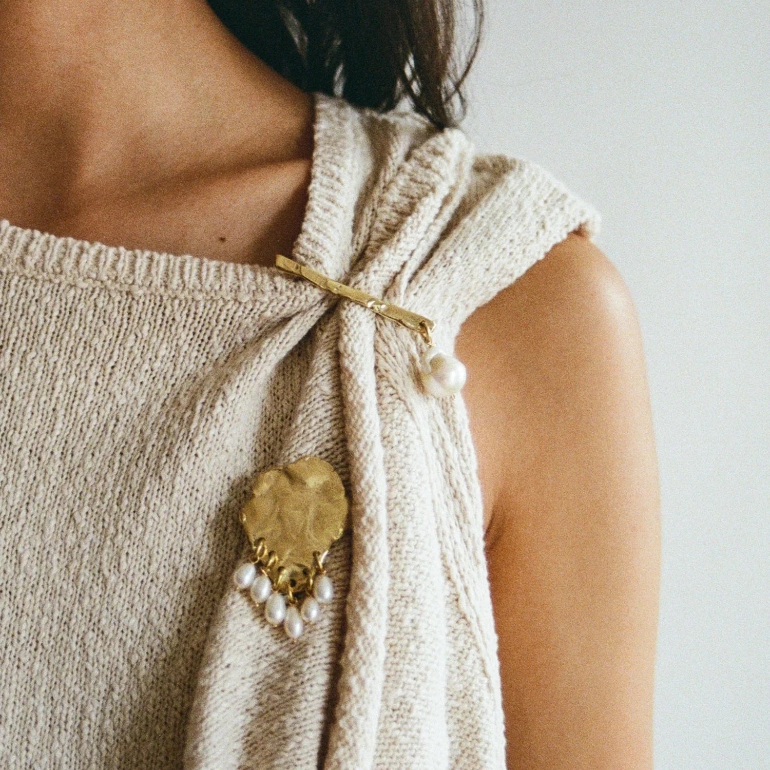 A woman wears brass and pearl brooches handmade by Canadian jewellery designer Michelle Ross from Toronto