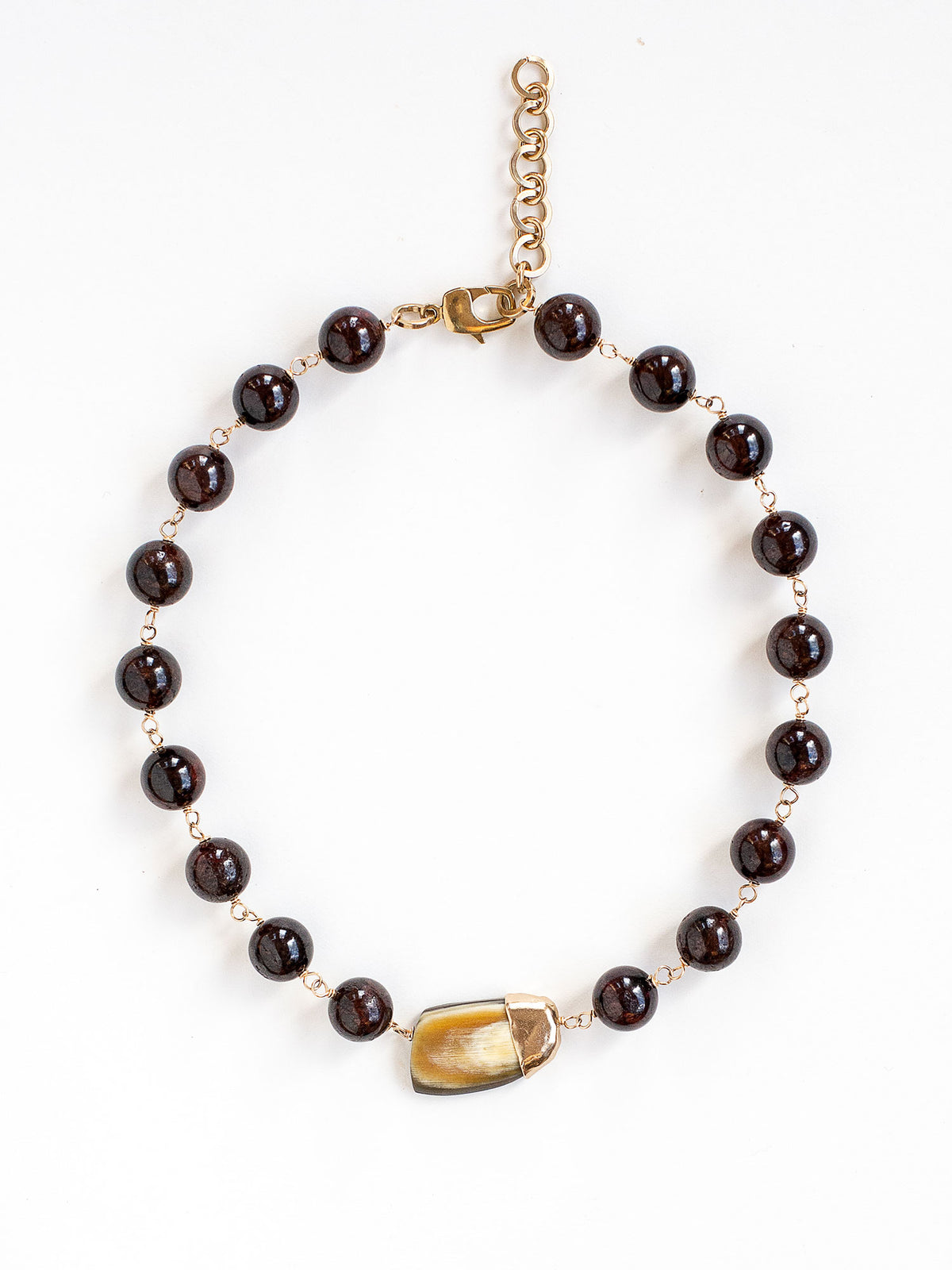 Beaded garnet collar necklace with a large horn pendant and brass details by Michelle Ross