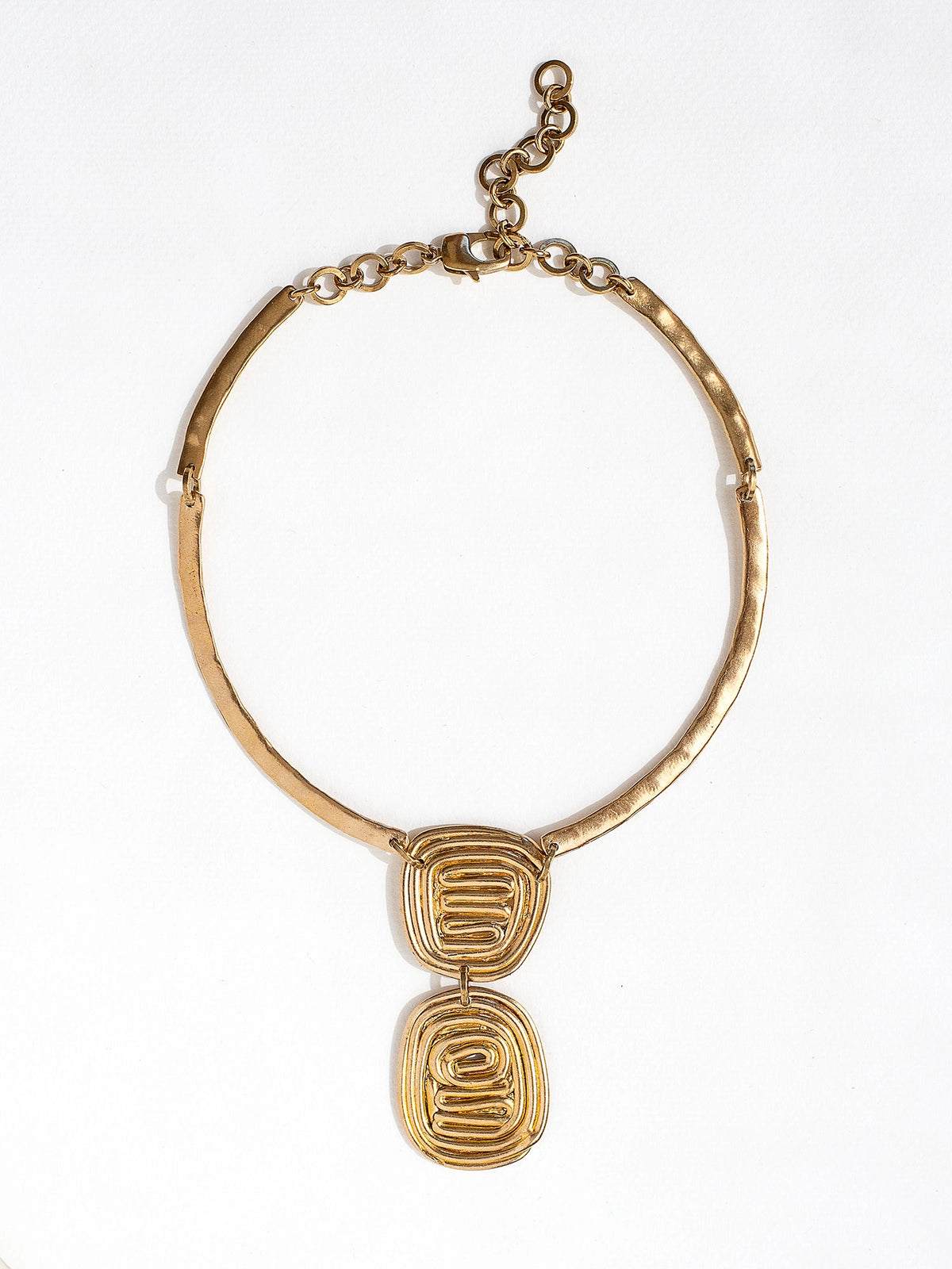 A solid brass collar necklace with a layered circular spiral pendants by Canadian jewelry designer Michelle Ross