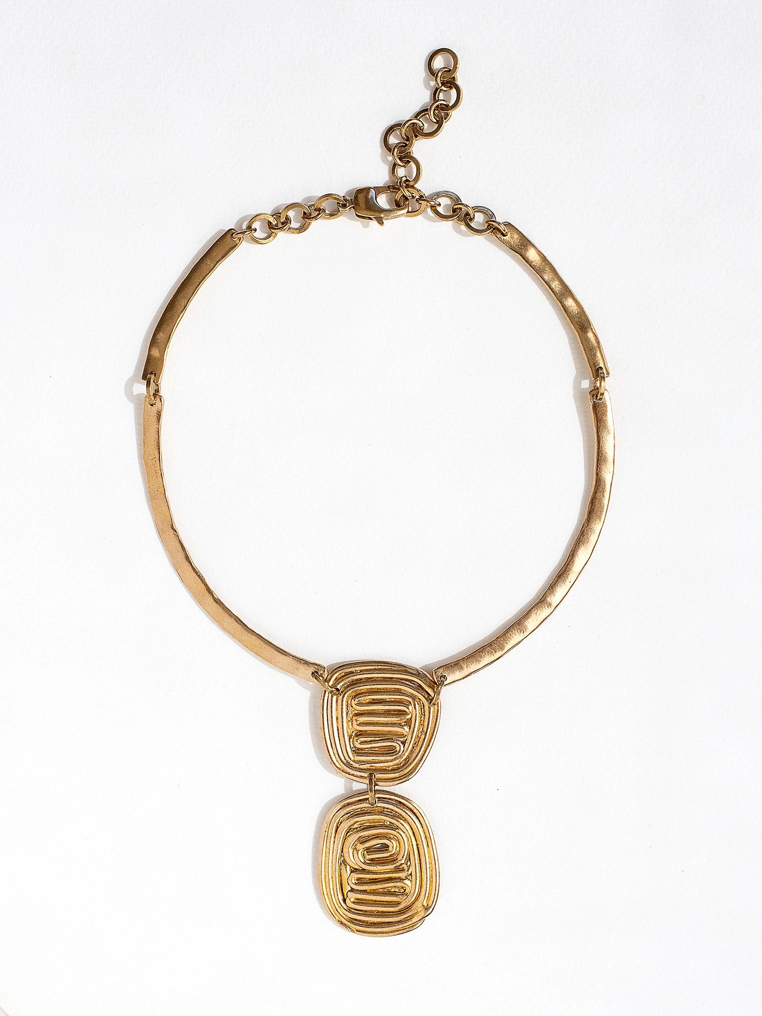 A solid brass collar necklace with a layered circular spiral pendants by Canadian jewelry designer Michelle Ross