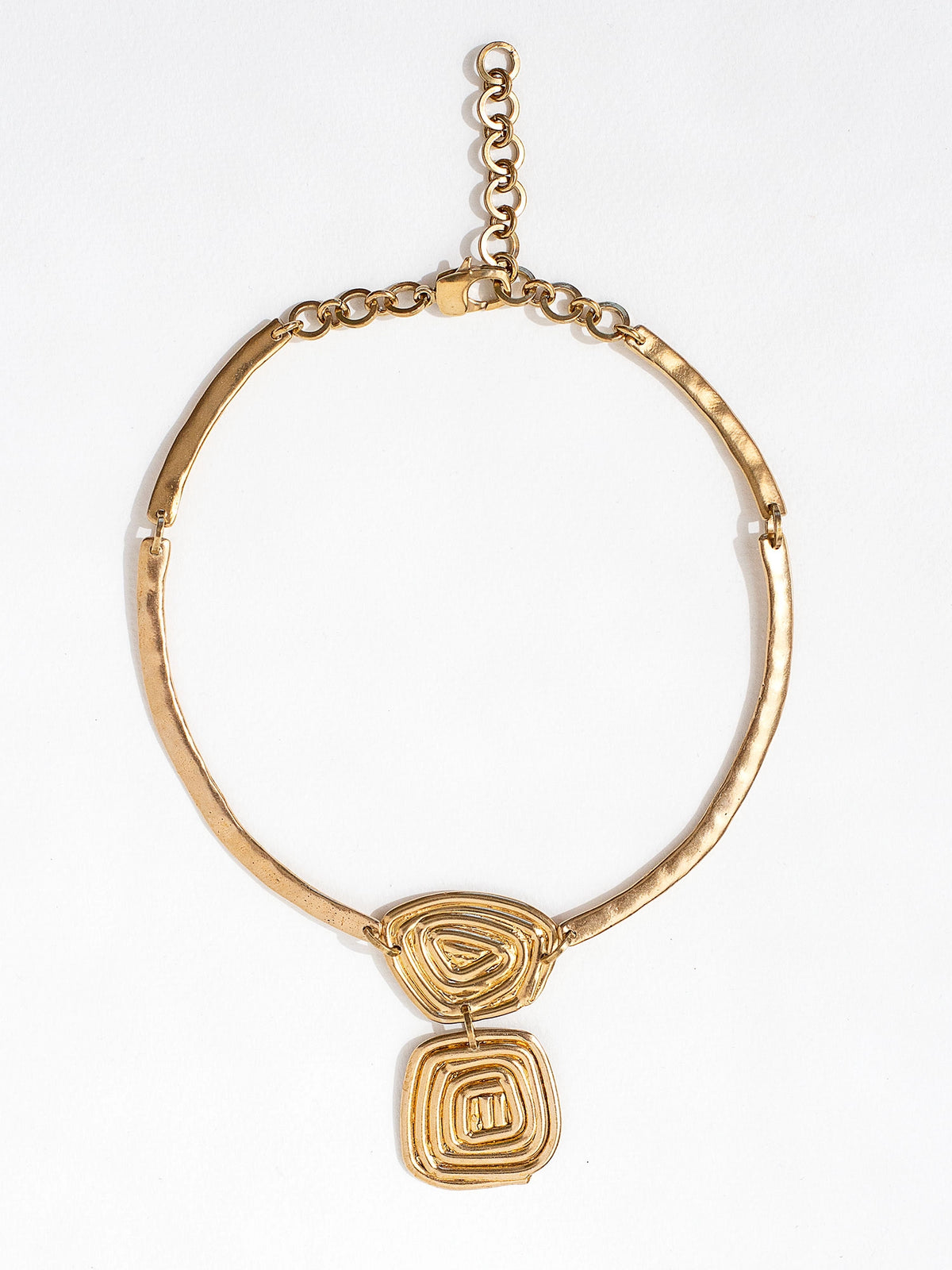 A solid brass collar necklace with a layered circular spiral pendants by Canadian jewelry designer Michelle Ross