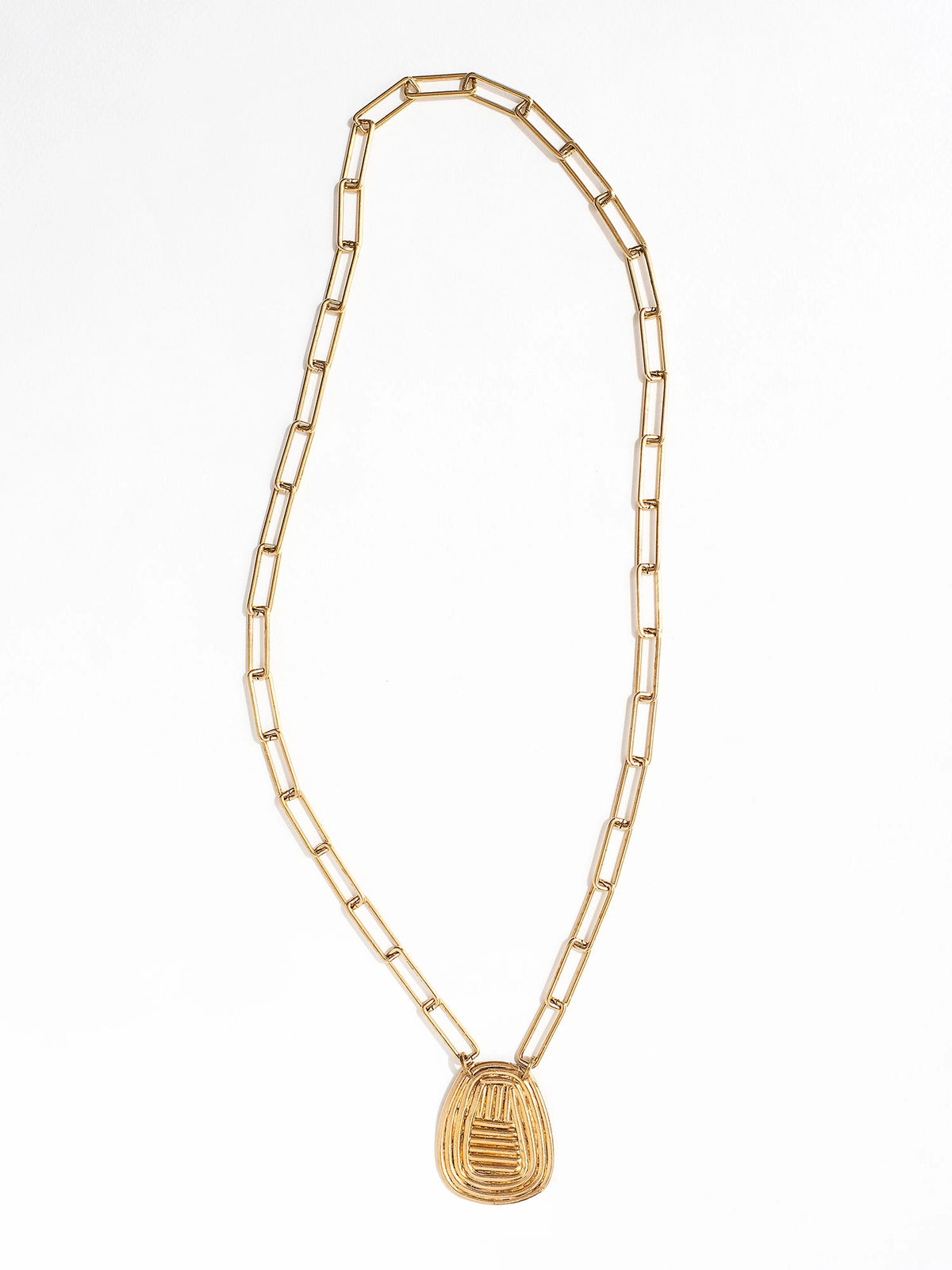 A brass chain link necklace with spiral circular pendant handcrafted by Canadian jewelry designer Michelle Ross