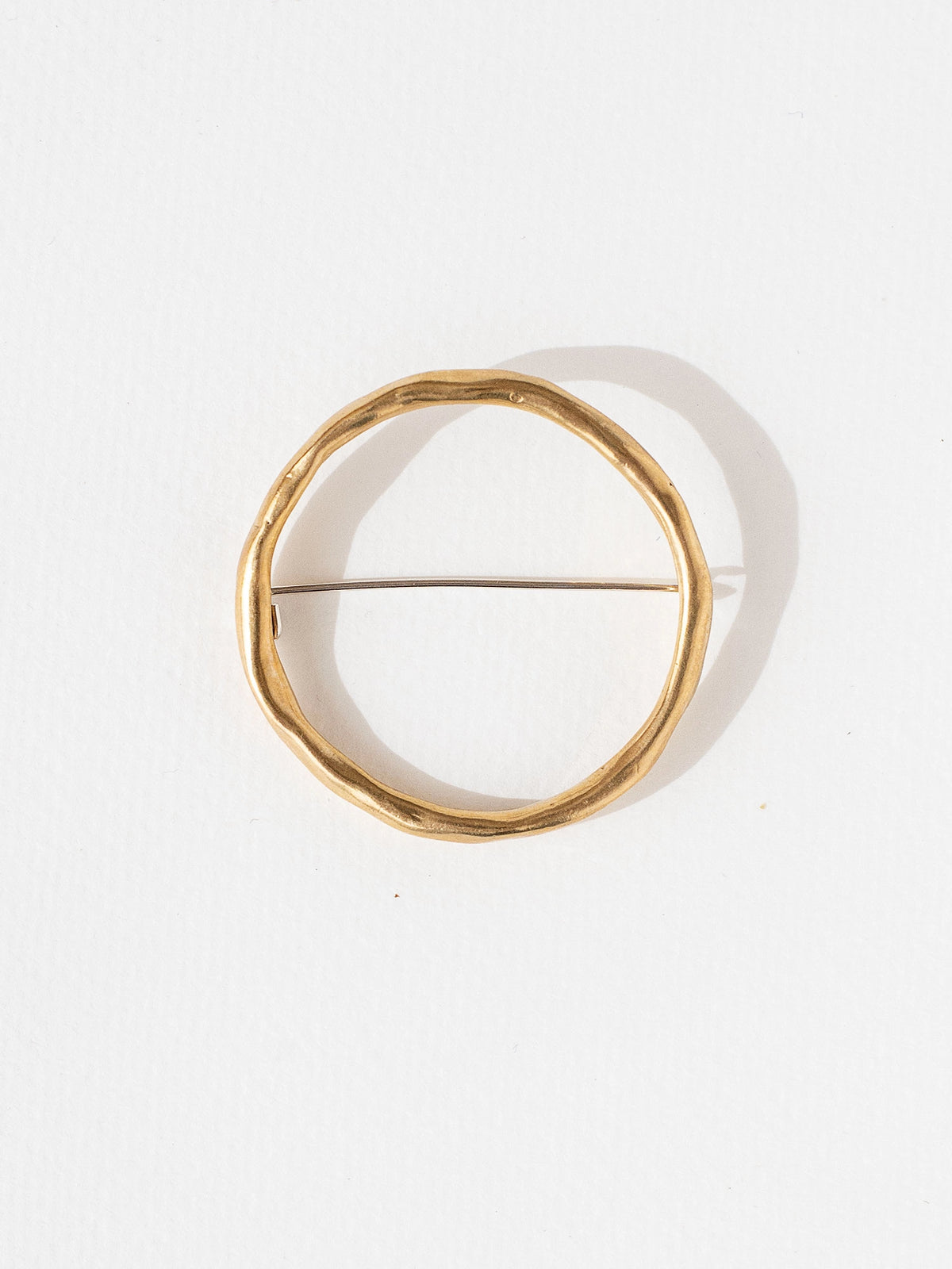 a circular handmade brass brooch by Toronto jewellery designer Michelle Ross