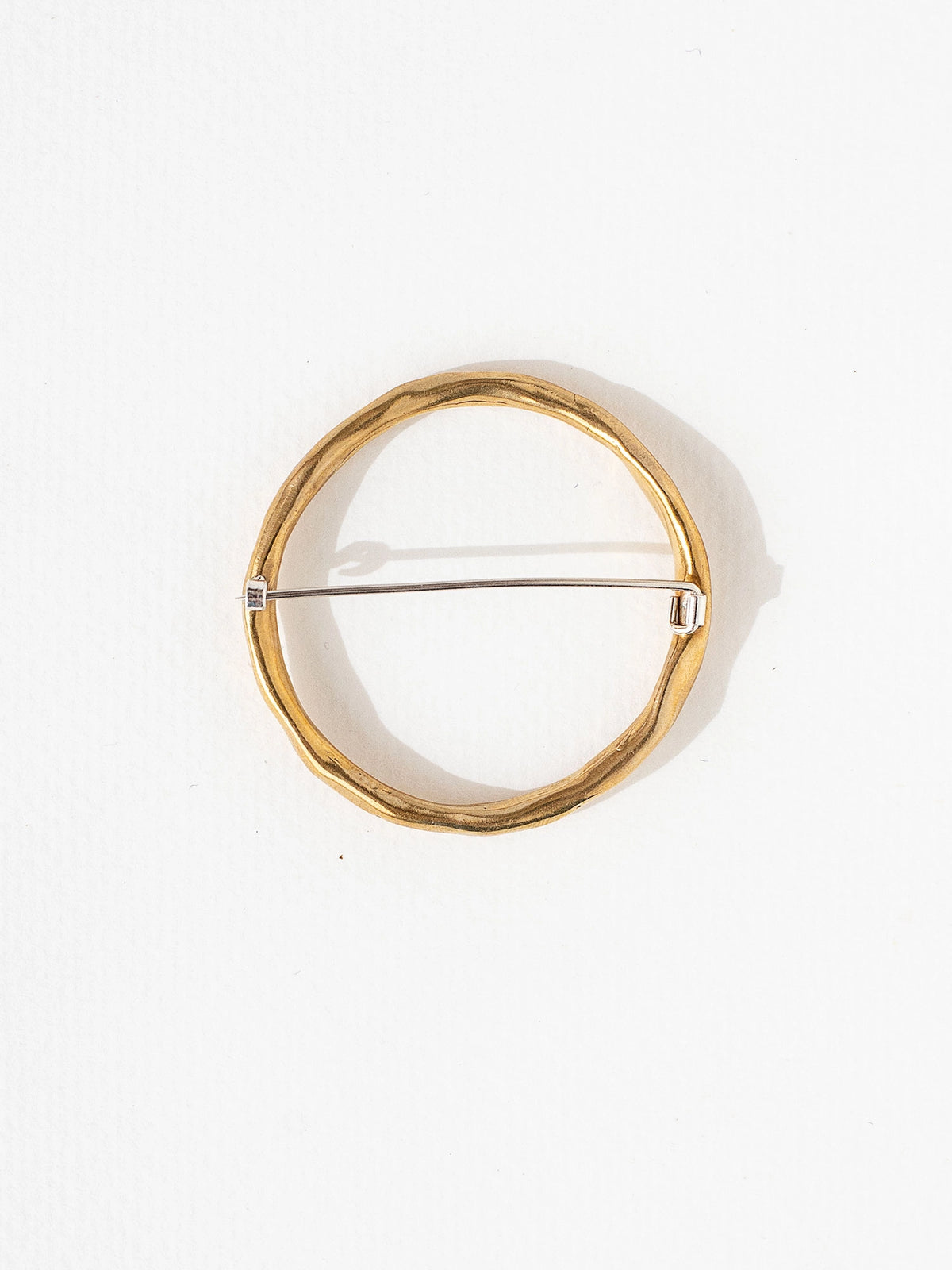 a circular handmade brass brooch by Toronto jewellery designer Michelle Ross