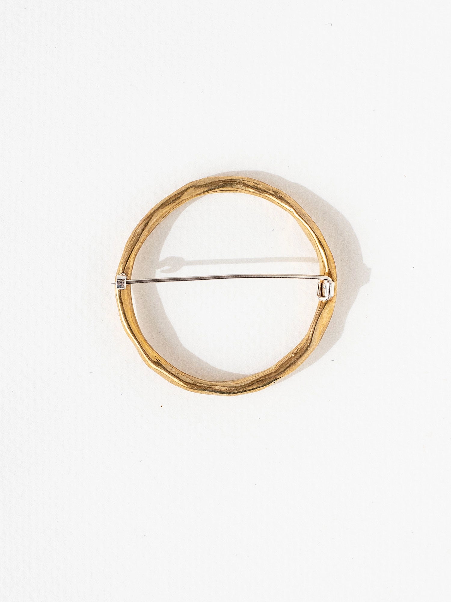 a circular handmade brass brooch by Toronto jewellery designer Michelle Ross
