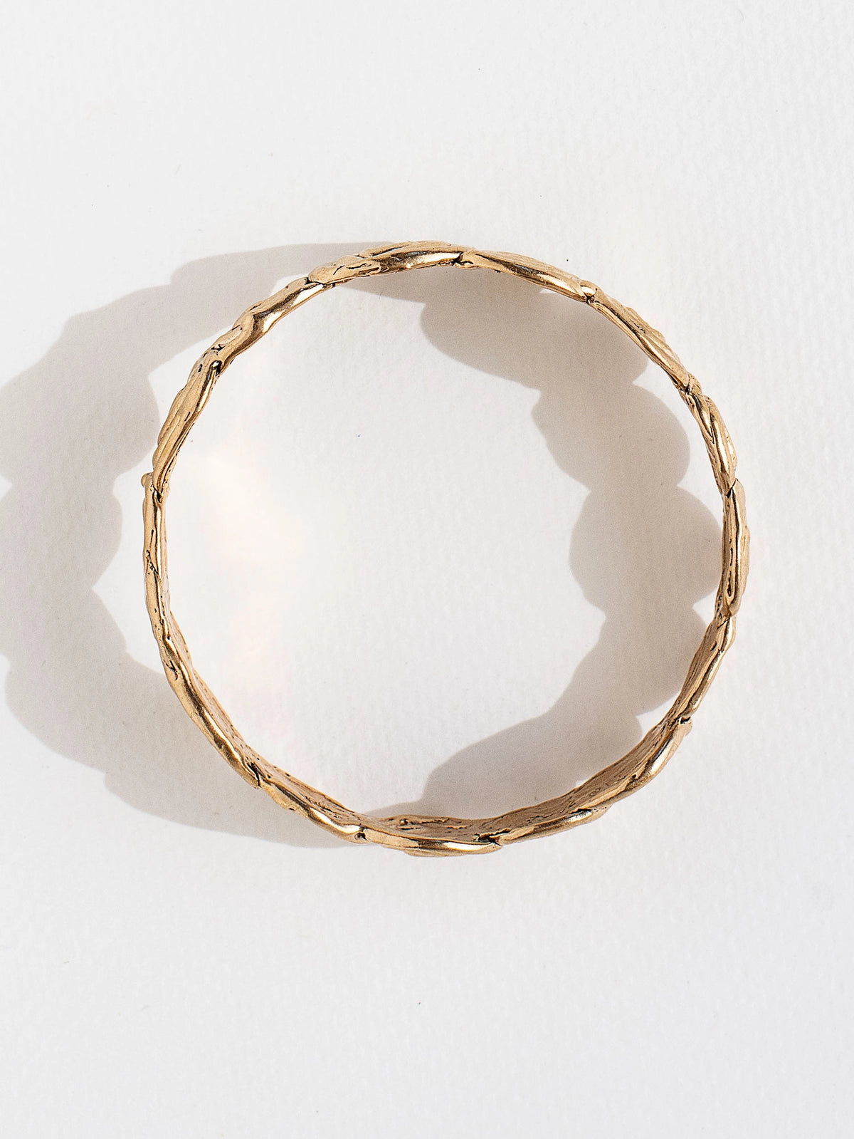 A solid brass bangle bracelet with swirl hand-formed details by Canadian jewelry designer Michelle Ross