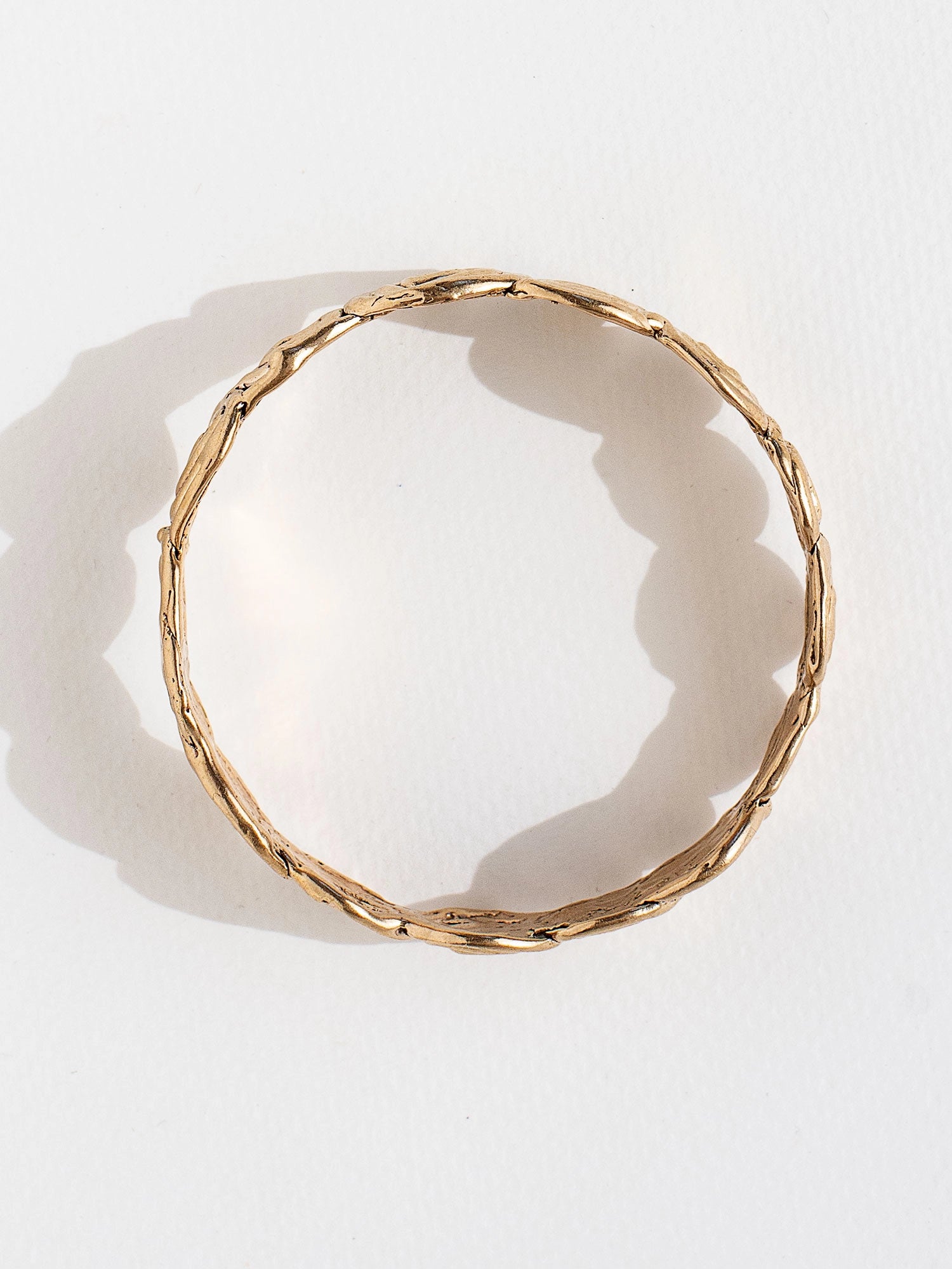 A solid brass bangle bracelet with swirl hand-formed details by Canadian jewelry designer Michelle Ross