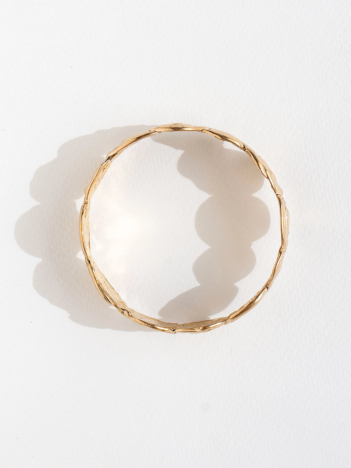 A solid brass bangle bracelet with swirl hand-formed details by Canadian jewelry designer Michelle Ross