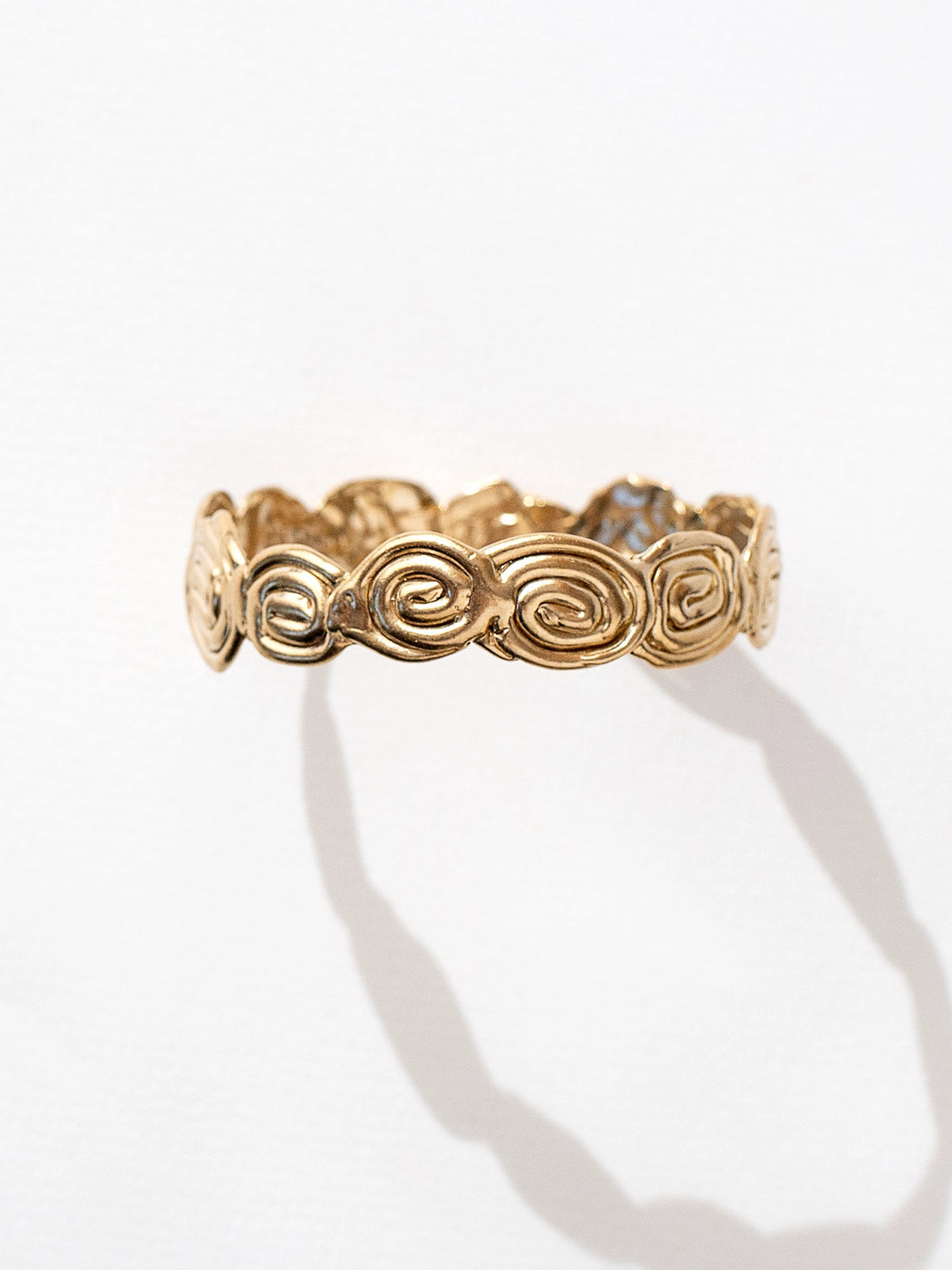 A solid brass bangle bracelet with swirl hand-formed details by Canadian jewelry designer Michelle Ross