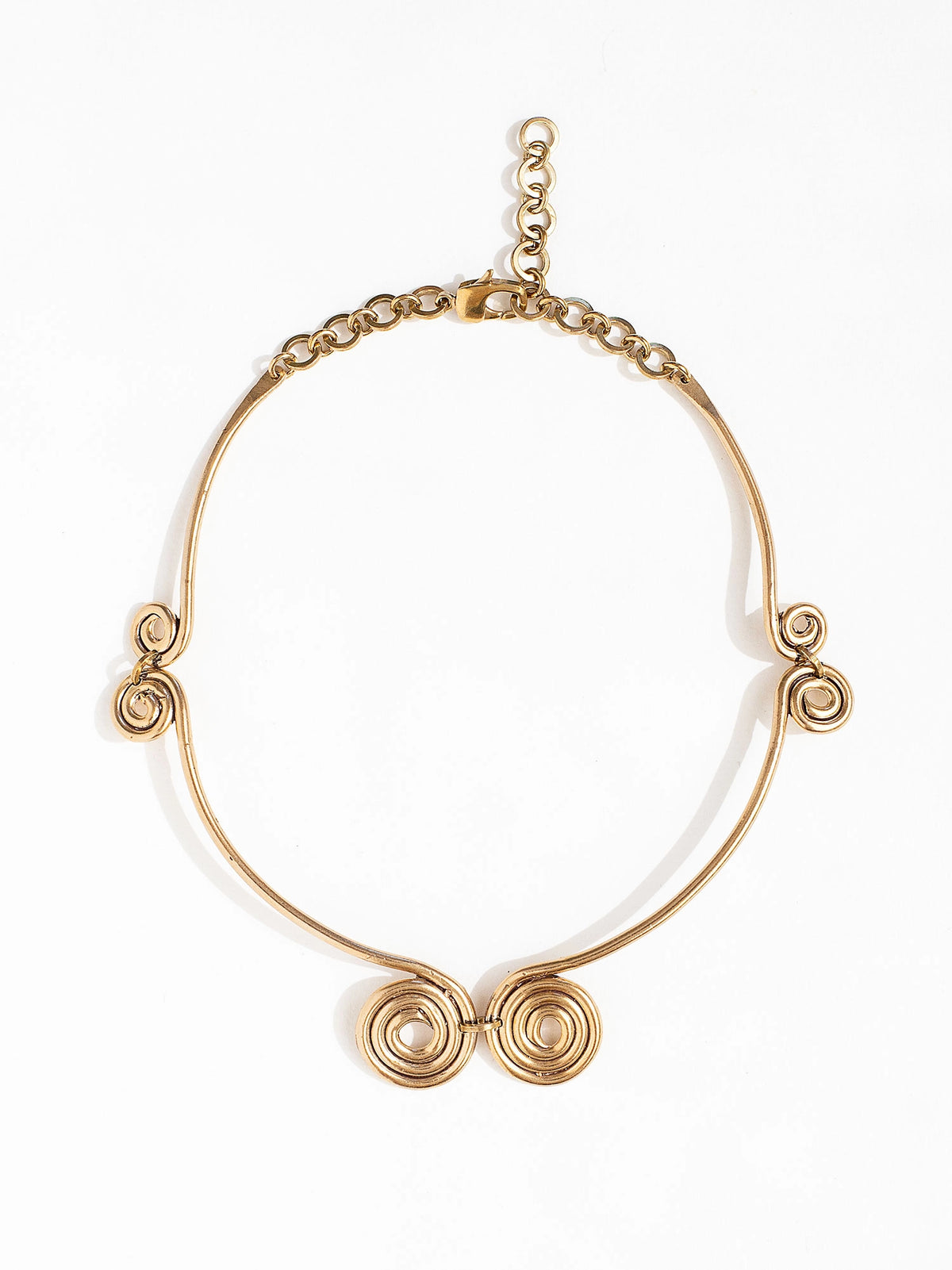 A solid brass collar necklace with several circular spiral details by Canadian jewelry designer Michelle Ross