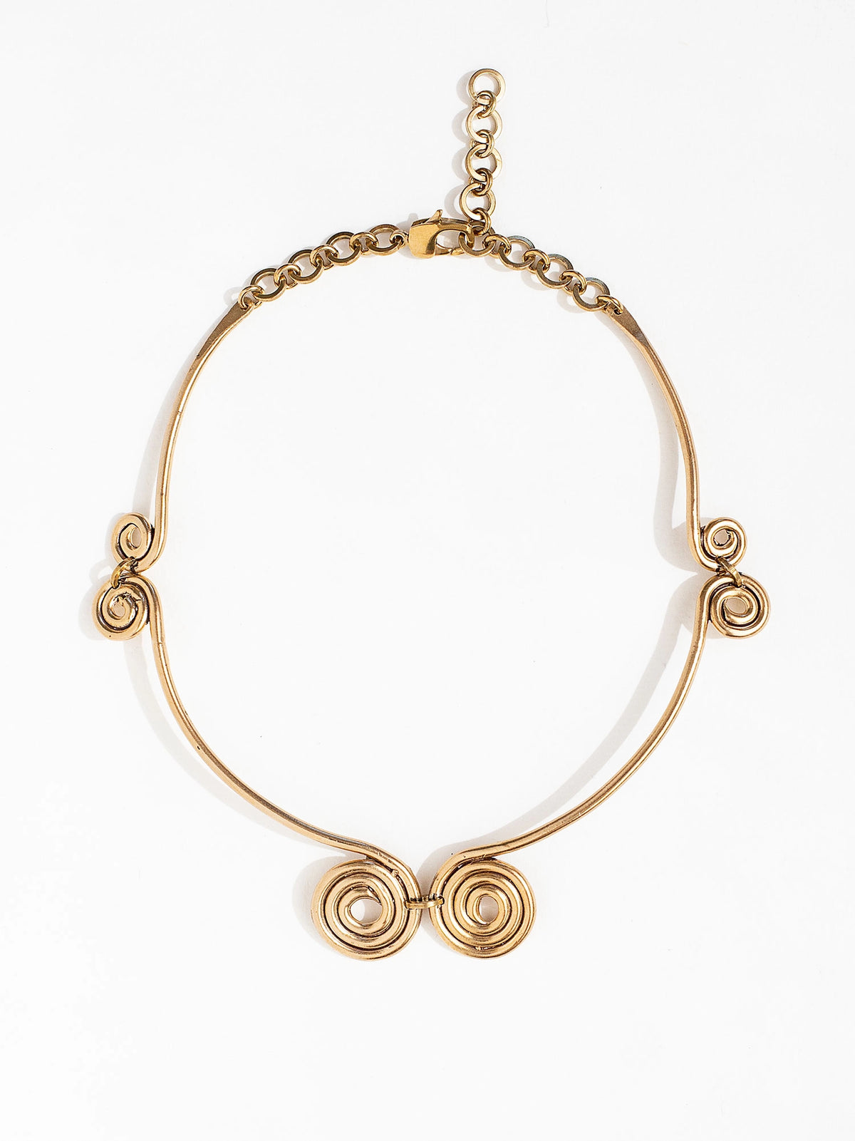 A solid brass collar necklace with several circular spiral details by Canadian jewelry designer Michelle Ross