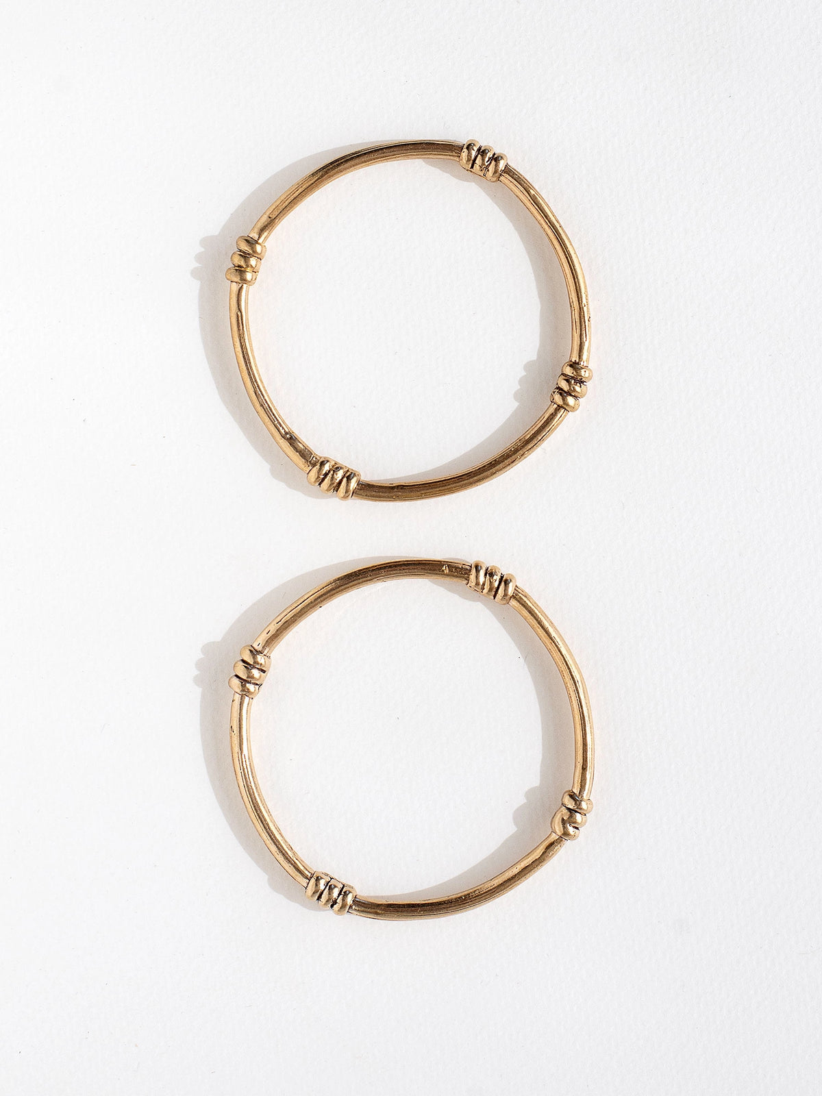 A solid brass bangle with scroll details by contemporary jewelry designer Michelle Ross