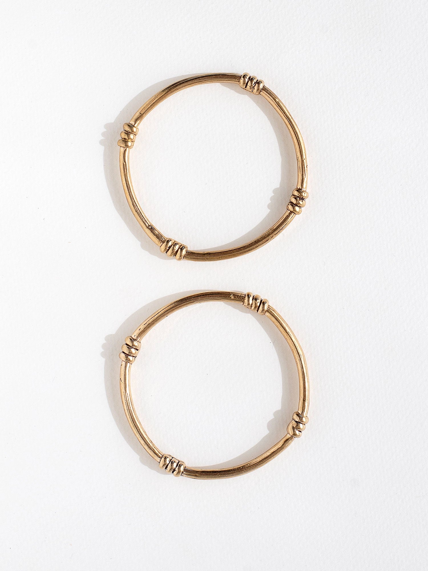 A solid brass bangle with scroll details by contemporary jewelry designer Michelle Ross