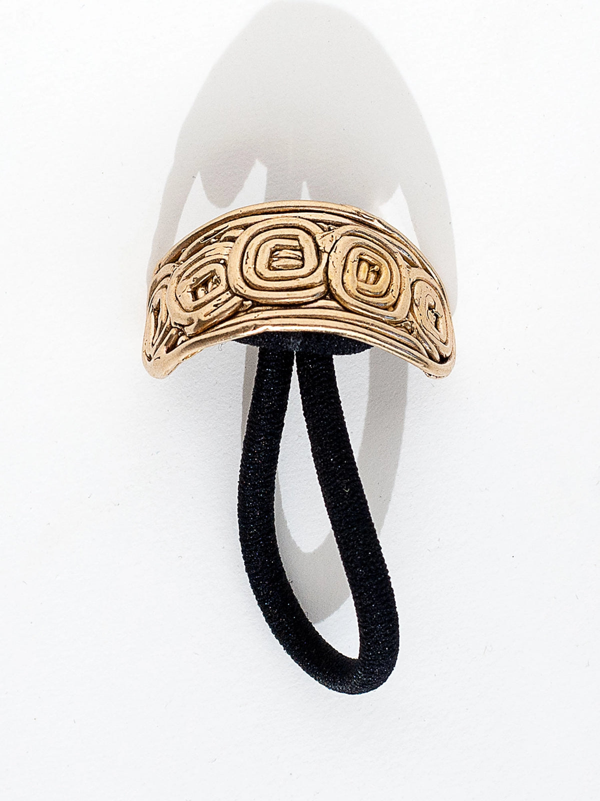 A brass solid hair tie with spiral scroll detail by Canadian jewelry designer Michelle Ross