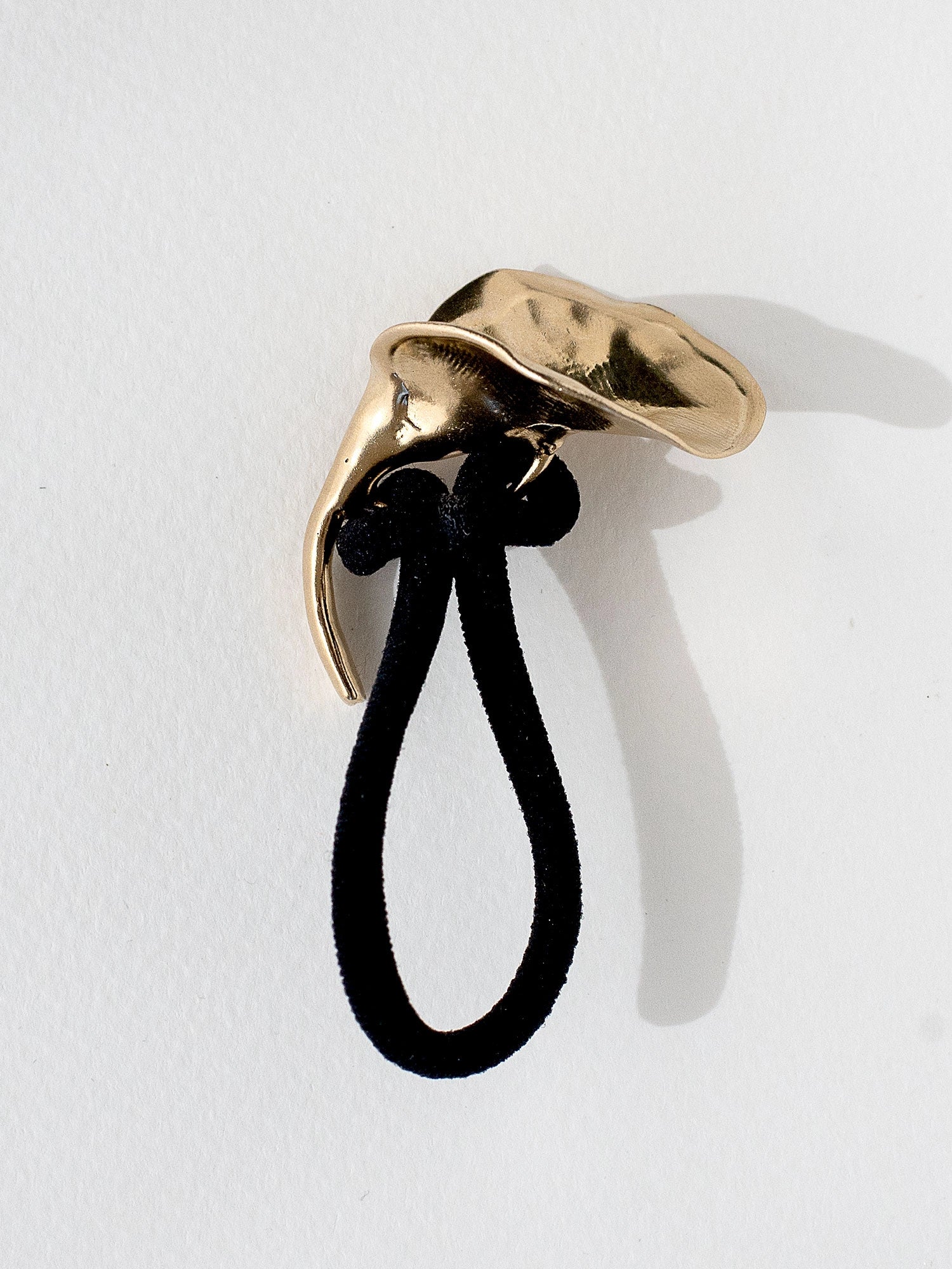 A brass brooch in an abstract floral shape by Canadian designer Michelle Ross
