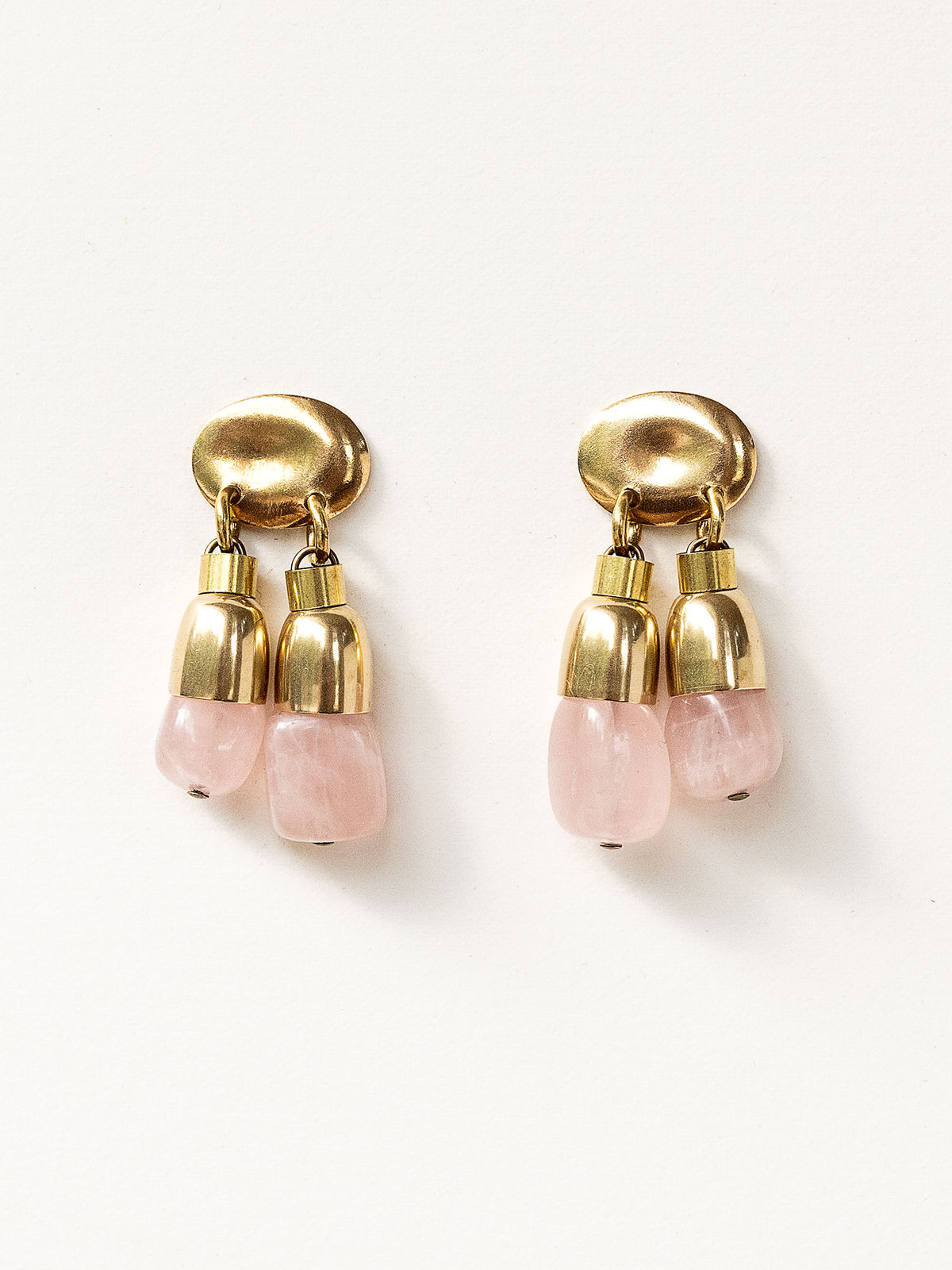 A pair of brass drop earrings with oval posts and two dangling pink stone rose quartz beads by Canadian jewelry designer Michelle Ross