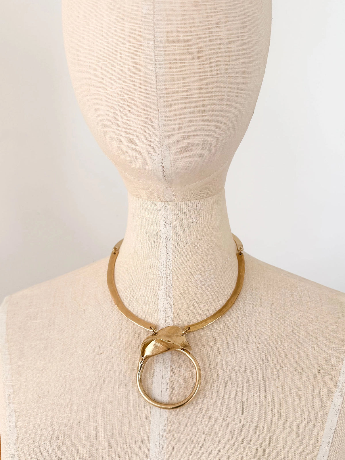 A solid brass collar necklace with a statement floral brass pendant by Canadian designer Michelle Ross