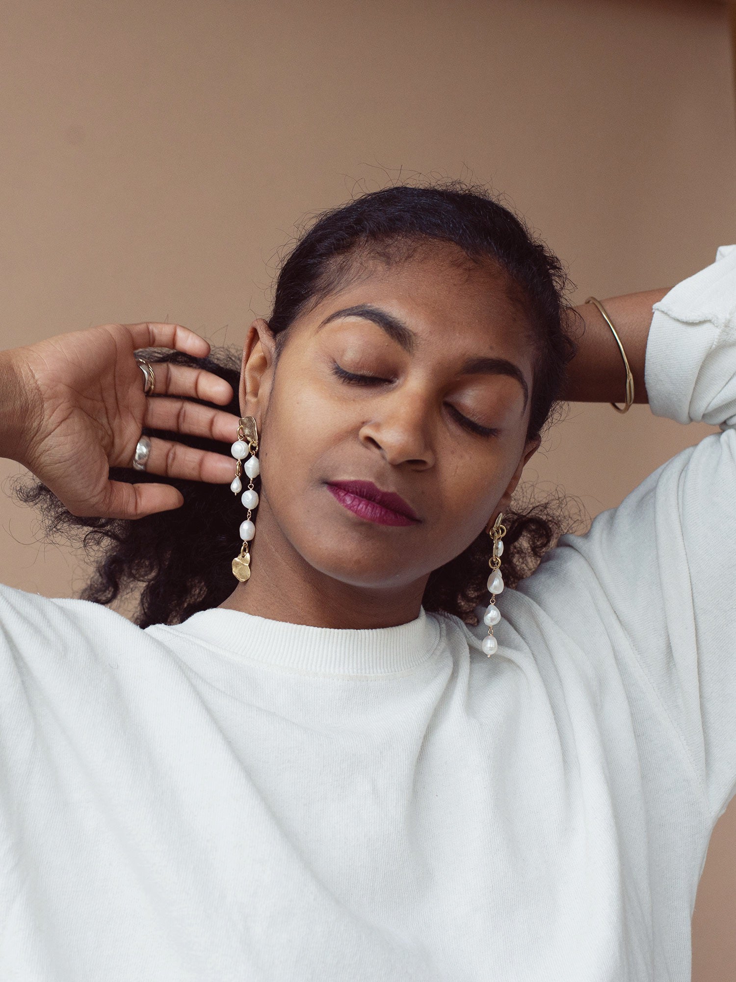 Pair of gold and pearl asymmetric chandelier earrings by Michelle Ross