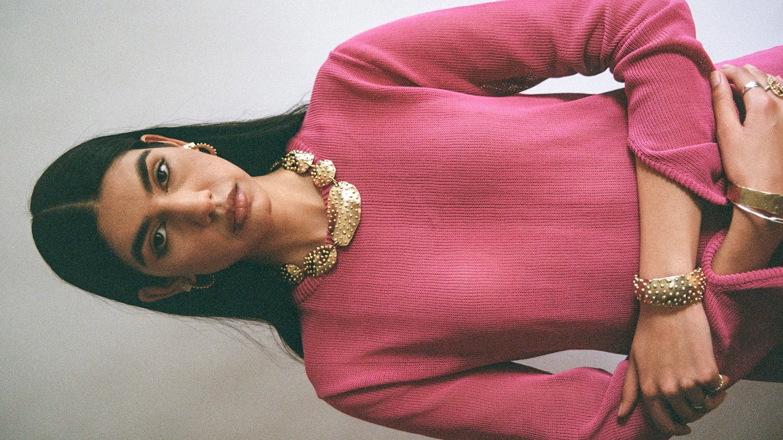 A woman wears brass jewelry handmade by Canadian jewellery designer Michelle Ross from Toronto including earrings, necklaces, cuffs, bangles, bracelets, statement rings and cocktail rings
