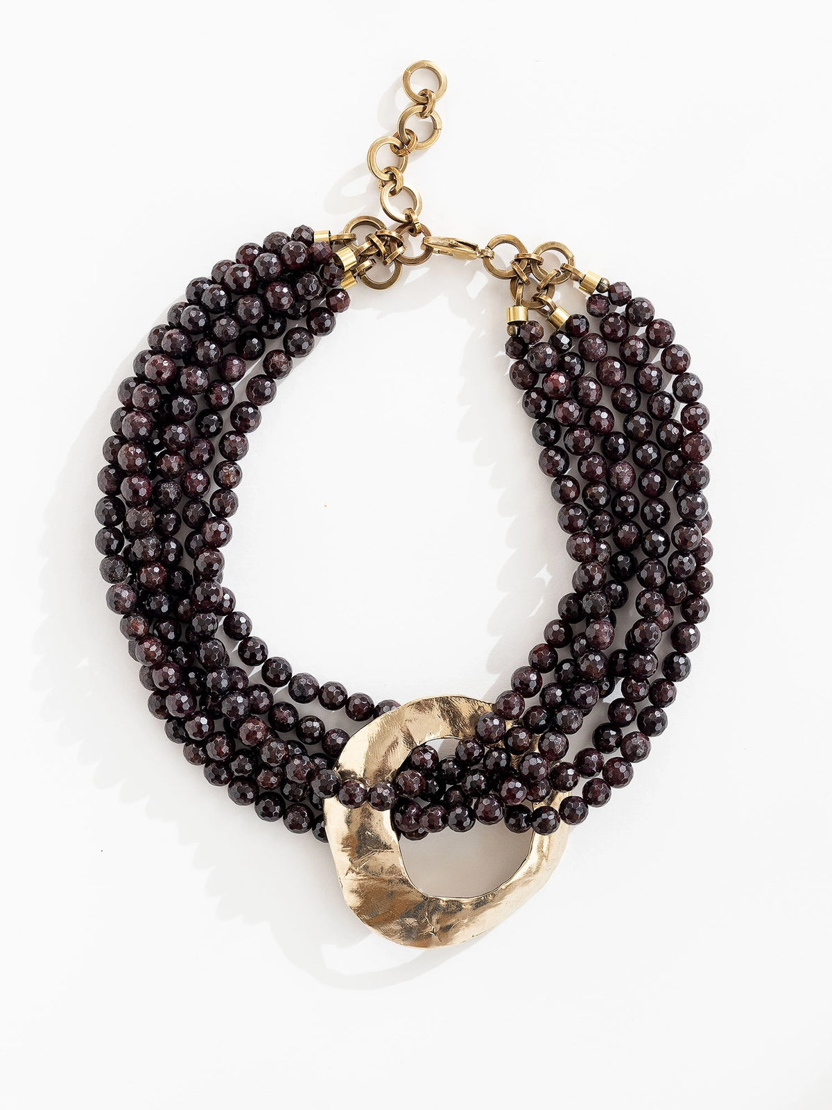 Multistrand beaded garnet necklace with a large central brass pendant by Michelle Ross