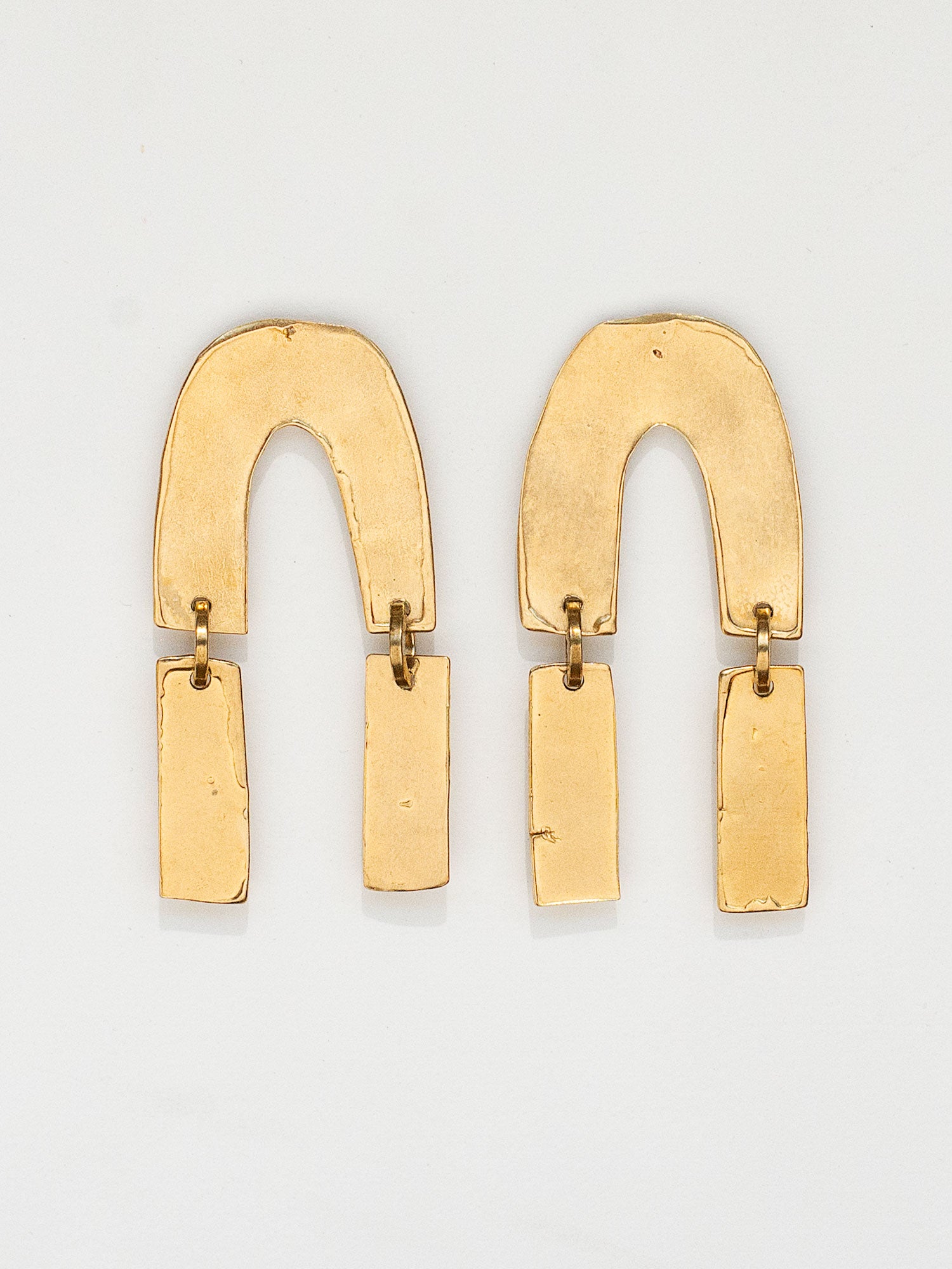 Pair of gold coloured brass statement earrings by Michelle Ross