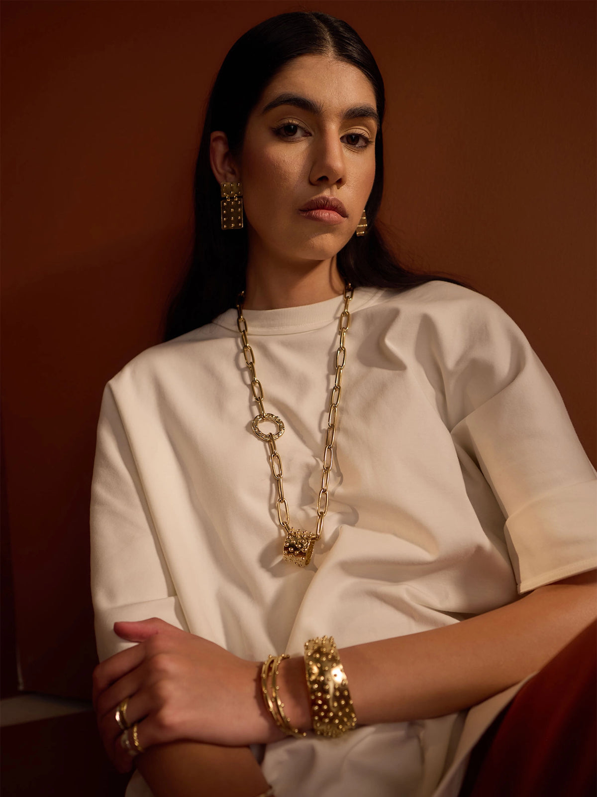 woman wears Lago Lightweight Rectangular Brass Statement Earrings by Michelle Ross