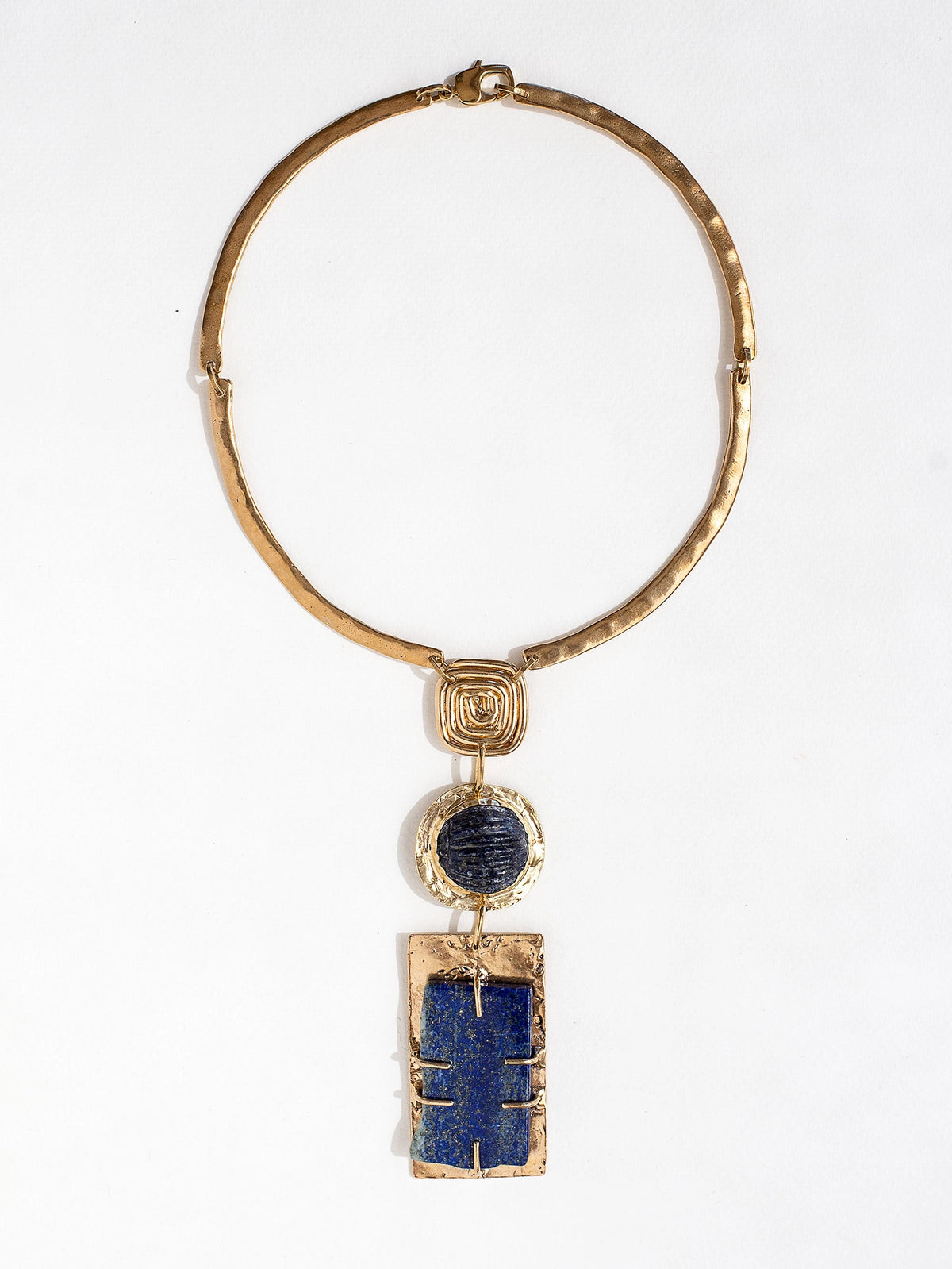 A solid brass collar necklace with a large statement lapis lazuli pendant by Canadian jewelry designer Michelle Ross