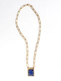 A brass chain link necklace with lapis lazuli and brass pendant handcrafted by Canadian jewelry designer Michelle Ross